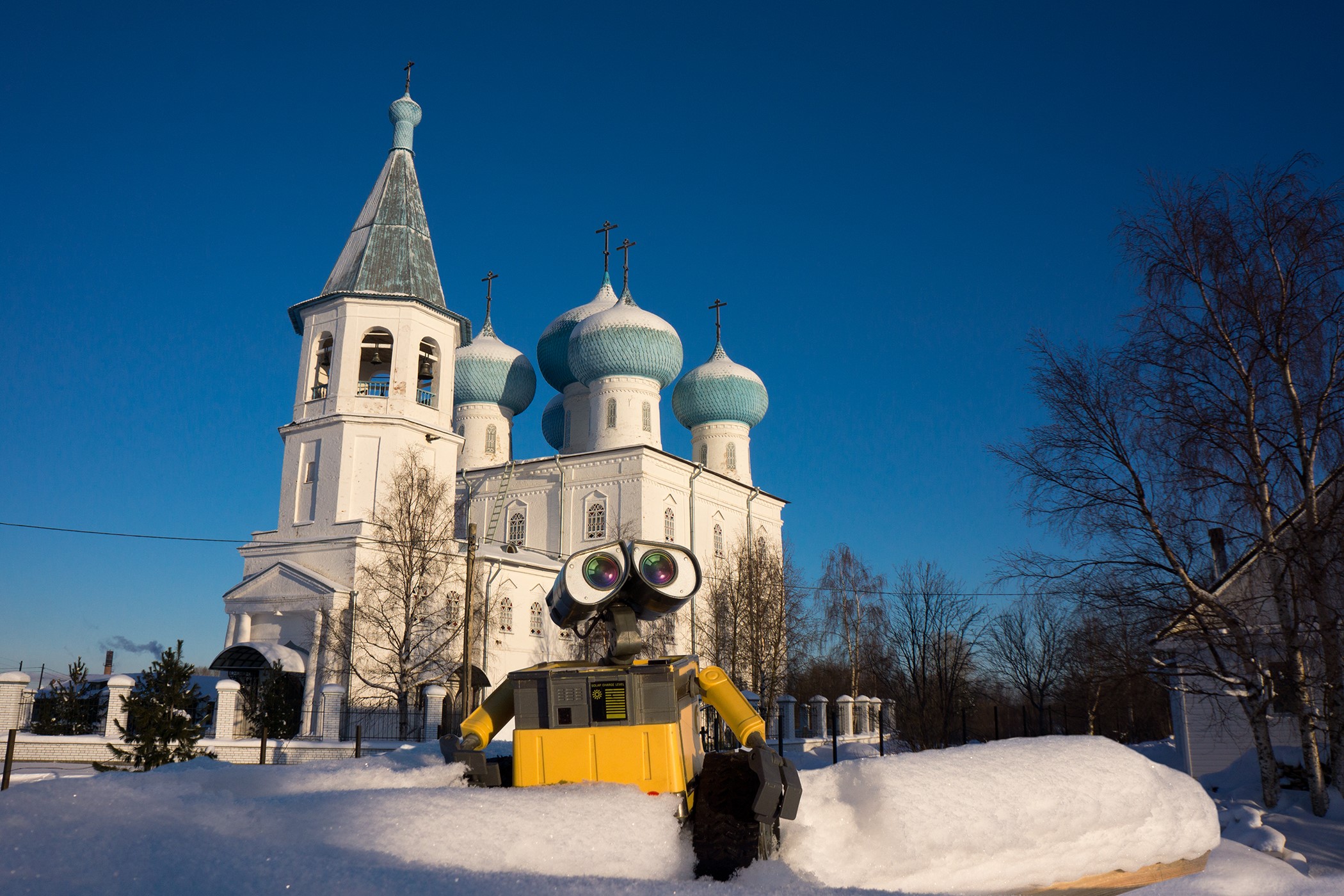 WALL-E robot in front of a snow-covered church HD Wallpaper