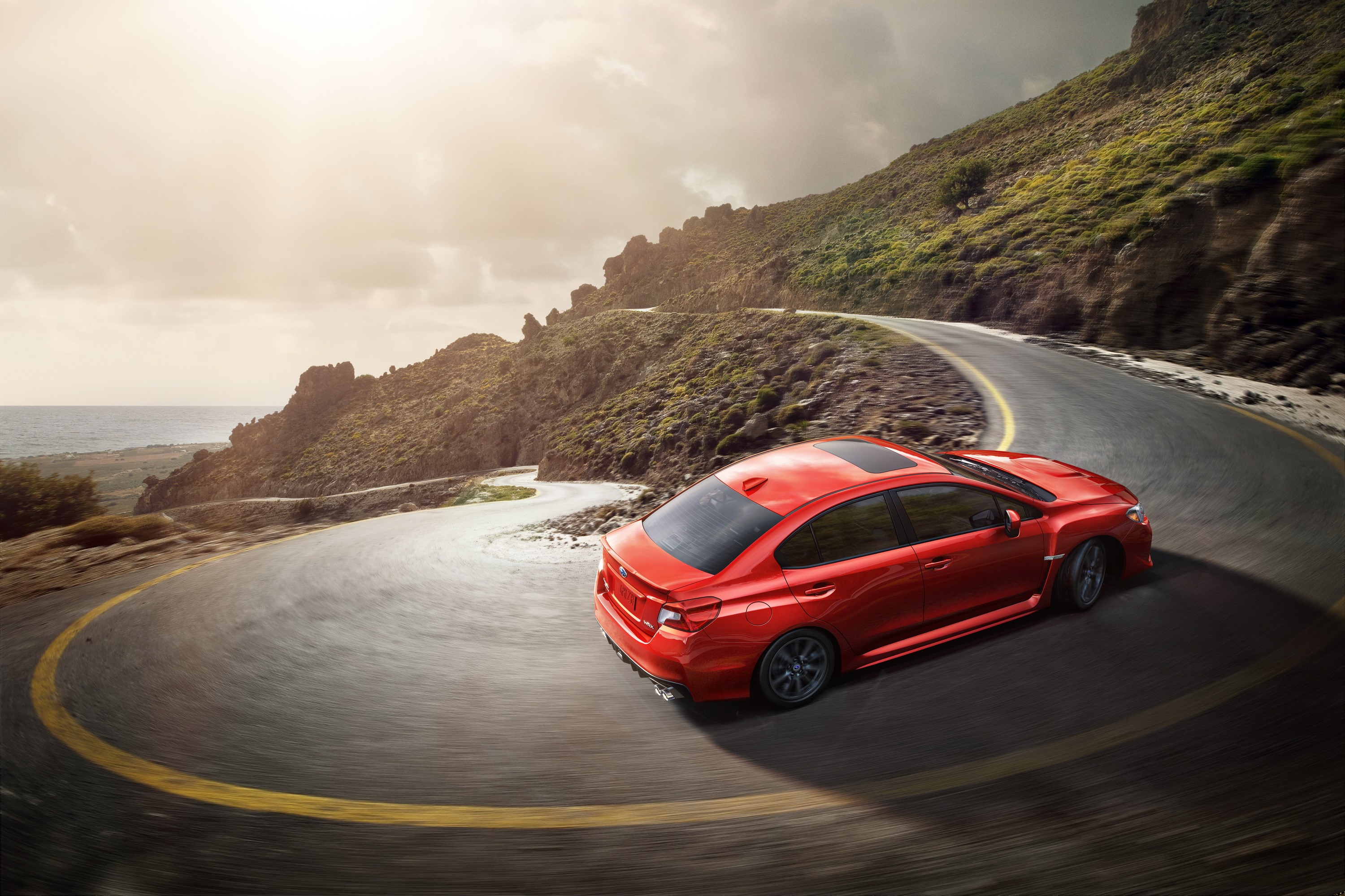 Red Subaru WRX on a winding mountain road HD Wallpaper