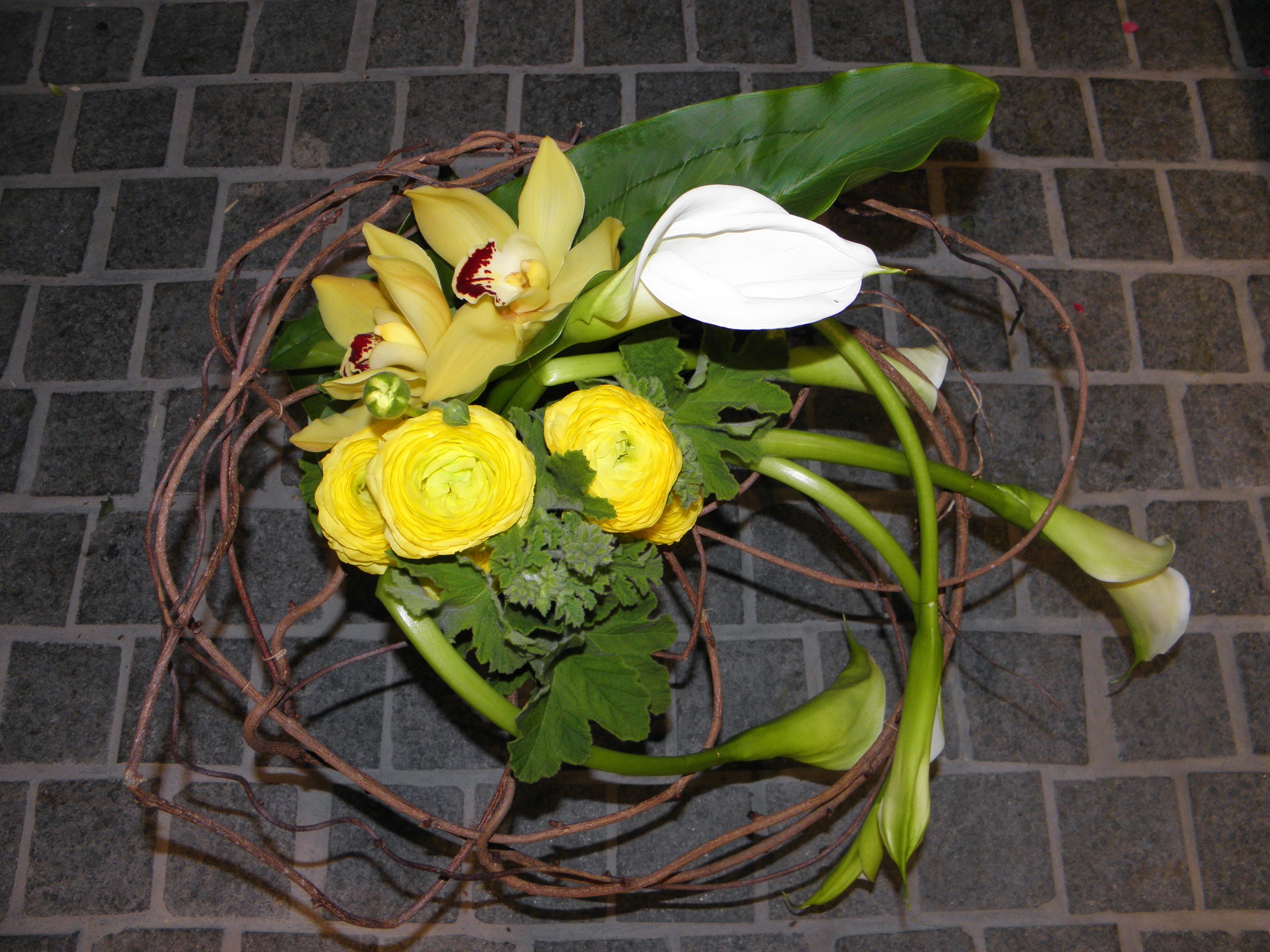 Yellow orchids, white calla lilies, and yellow ranunculus in a twig arrangement HD Wallpaper