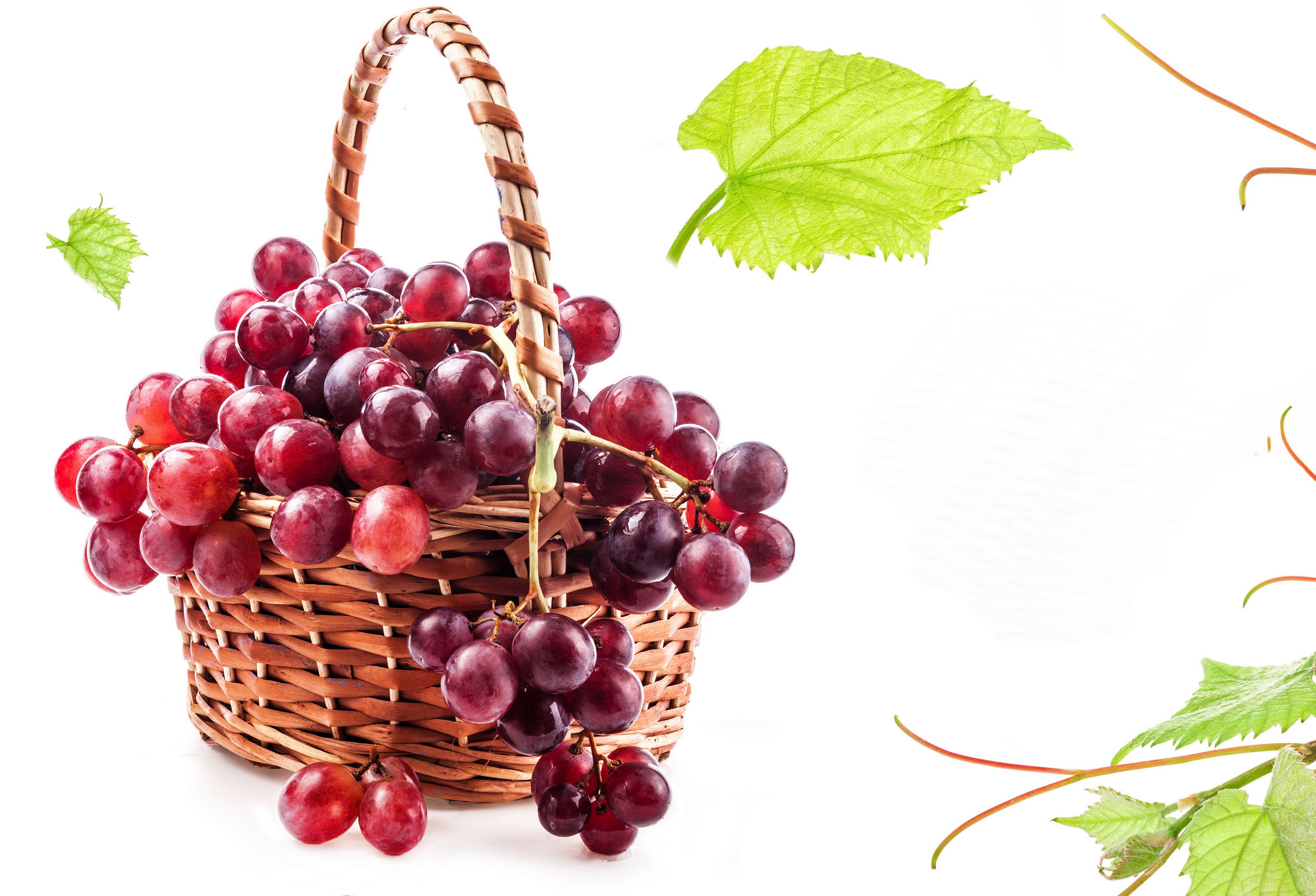 Red grapes in a wicker basket with green leaves HD Wallpaper