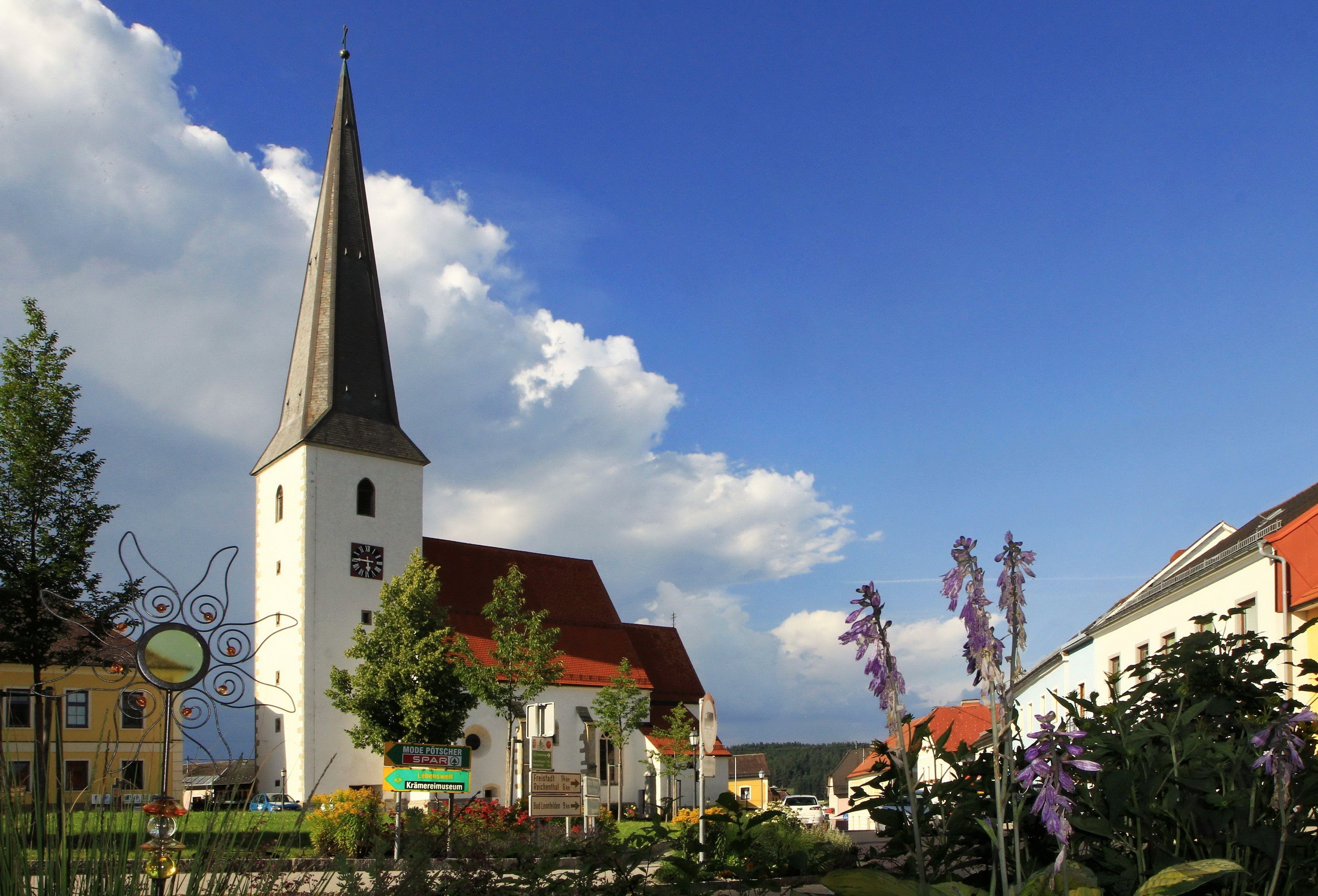 Church in Schenkenfelden with flowers and houses HD Wallpaper