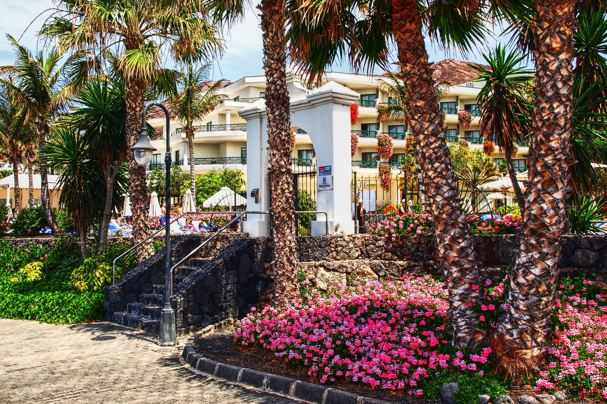 Resort with palm trees and flowers in Playa Blanca, Spain HD Wallpaper