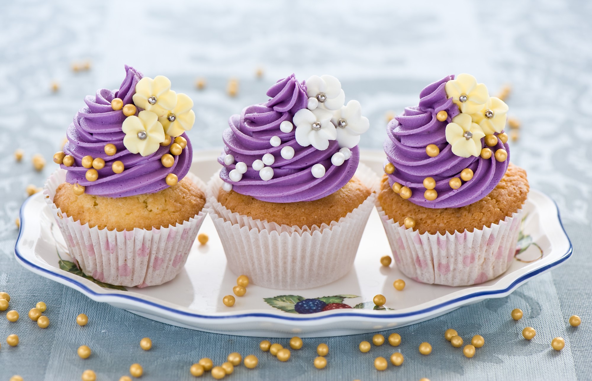 Three decorated cupcakes on a platter HD Wallpaper