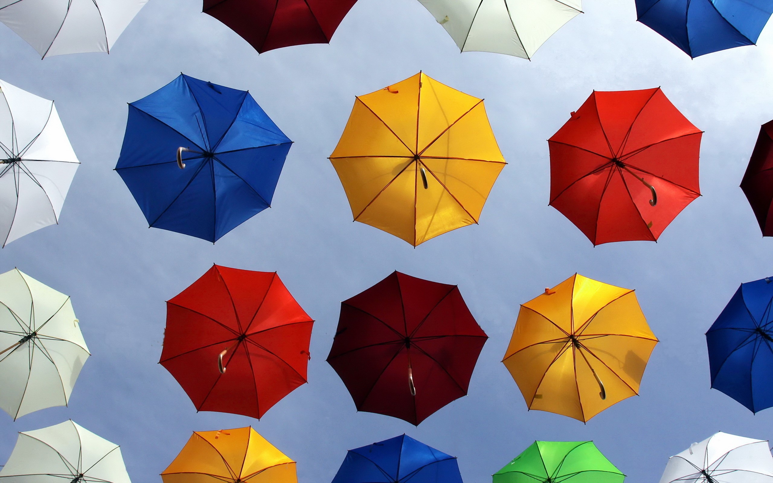 Many colorful umbrellas suspended in the sky HD Wallpaper