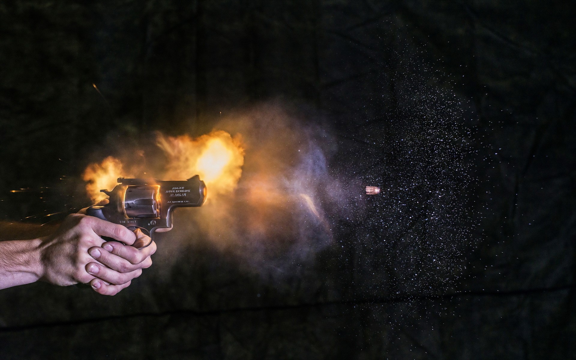 Revolver firing a bullet with muzzle flash HD Wallpaper