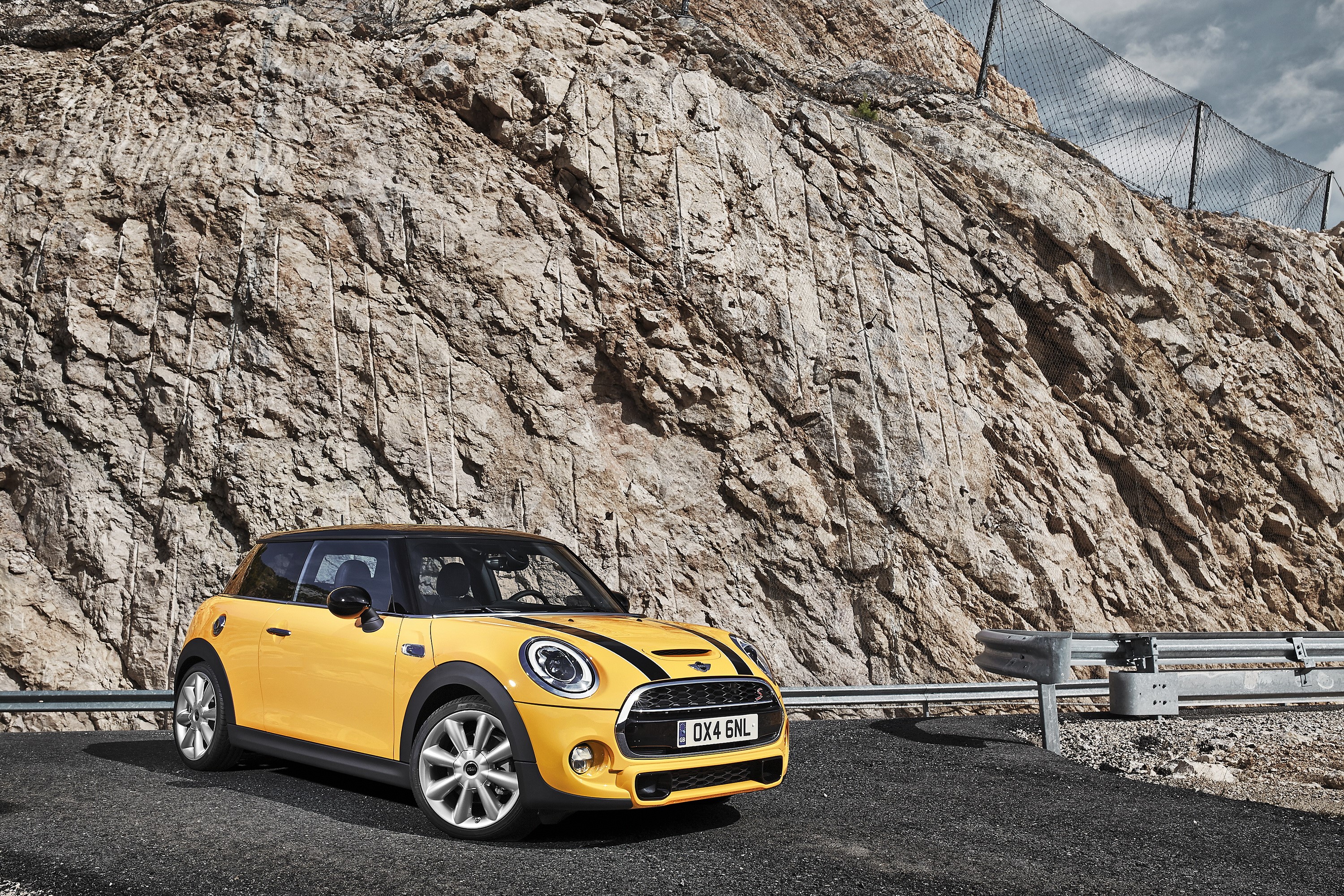 Yellow 2014 Mini Cooper S parked by a rocky cliff HD Wallpaper