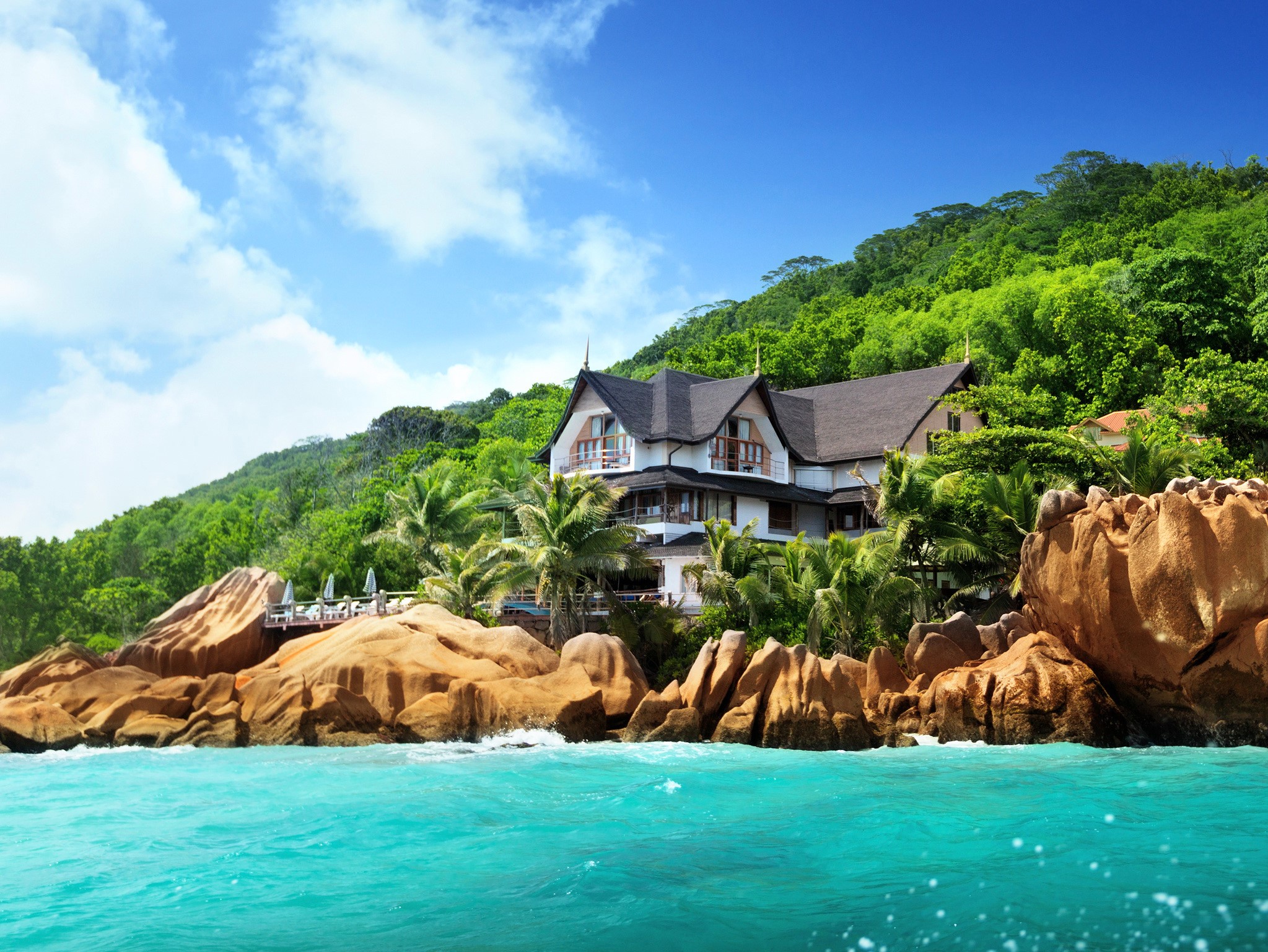 Tropical house on a rocky coast with turquoise sea HD Wallpaper