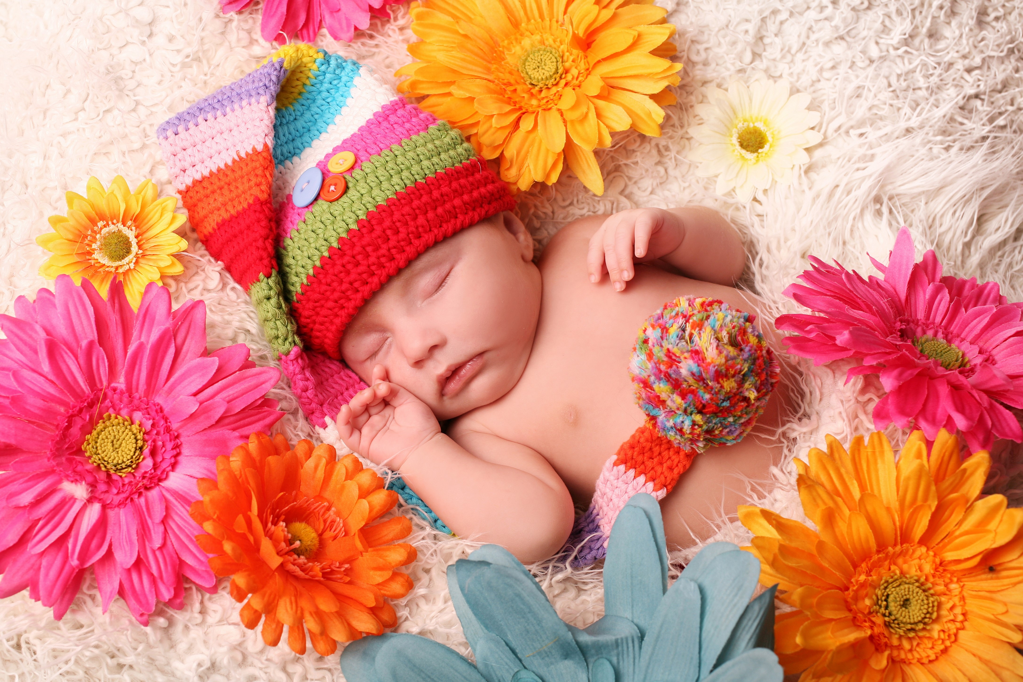 Baby sleeping with colorful flowers and hat HD Wallpaper