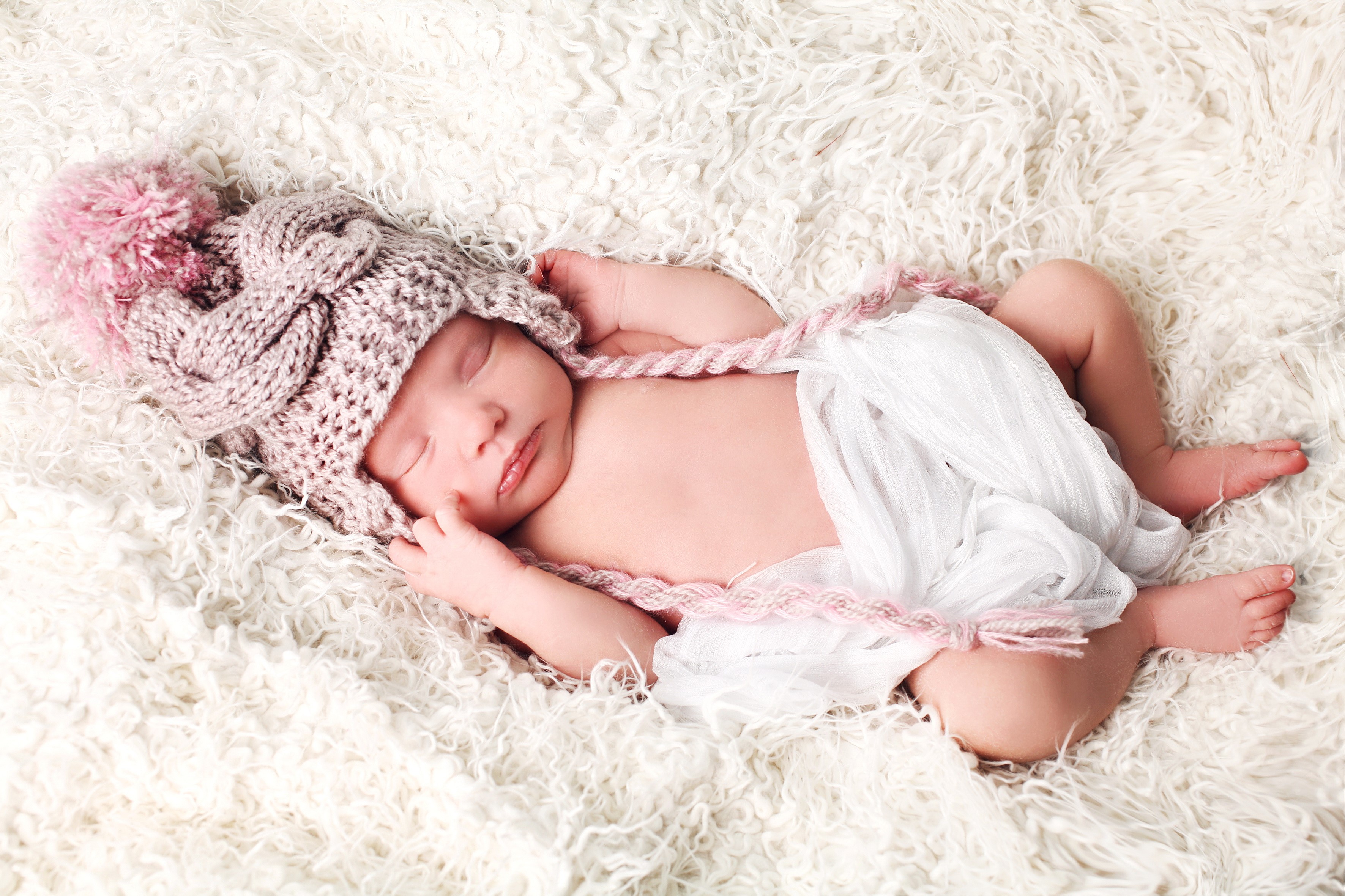 Newborn baby sleeping in a knitted hat HD Wallpaper