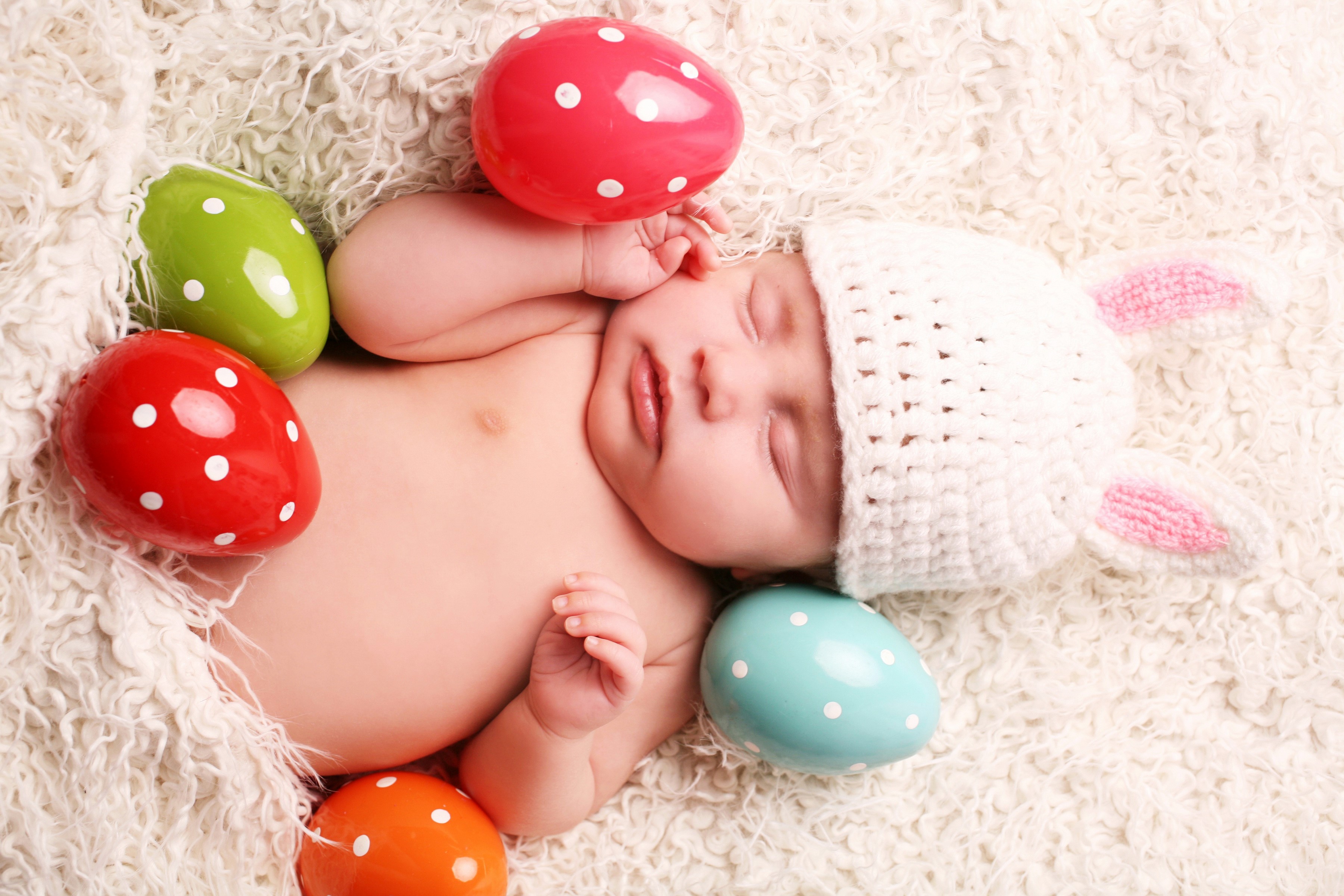 Baby in bunny hat sleeping with Easter eggs HD Wallpaper