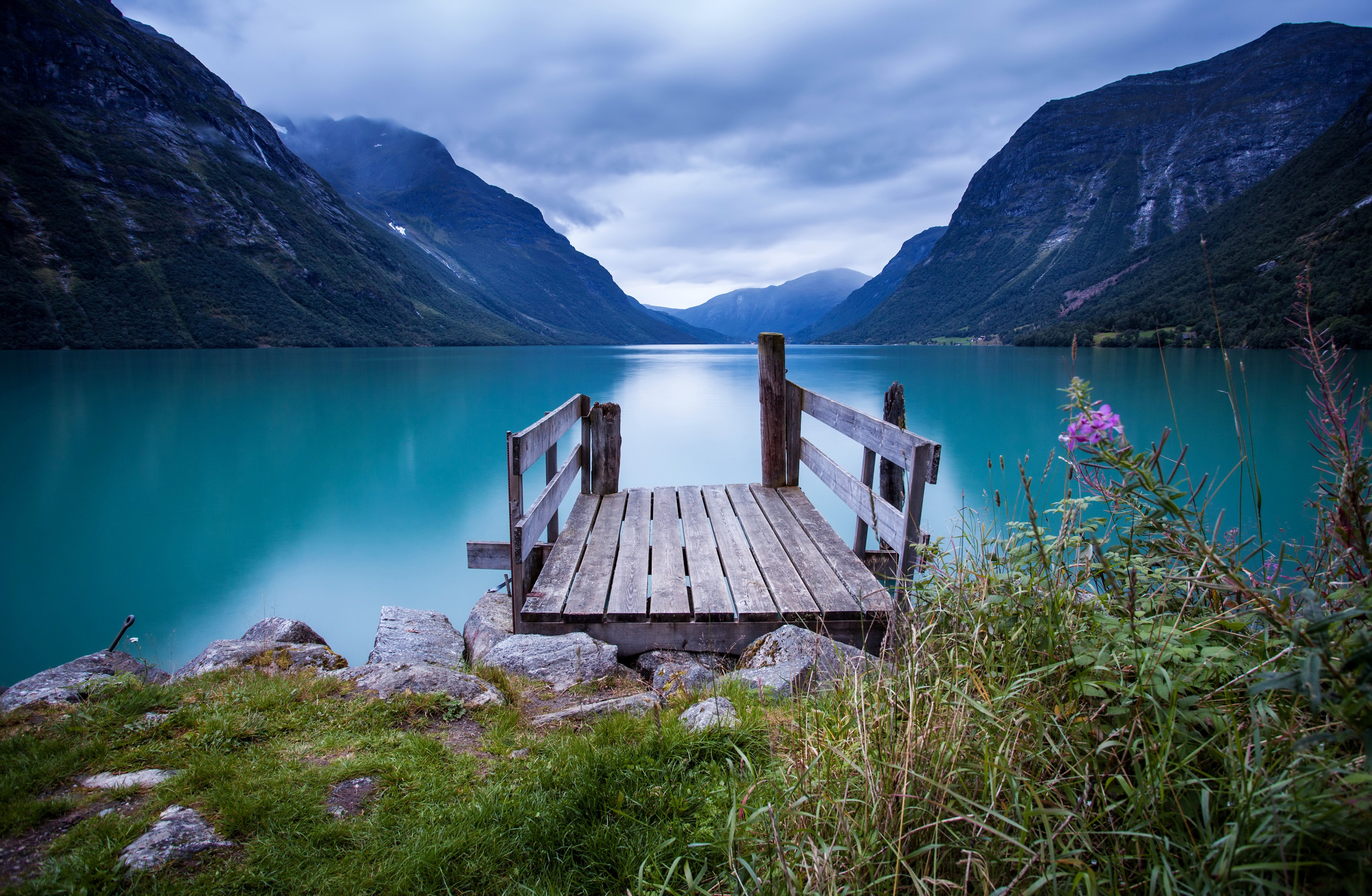 Wooden dock on a turquoise lake with mountains HD Wallpaper