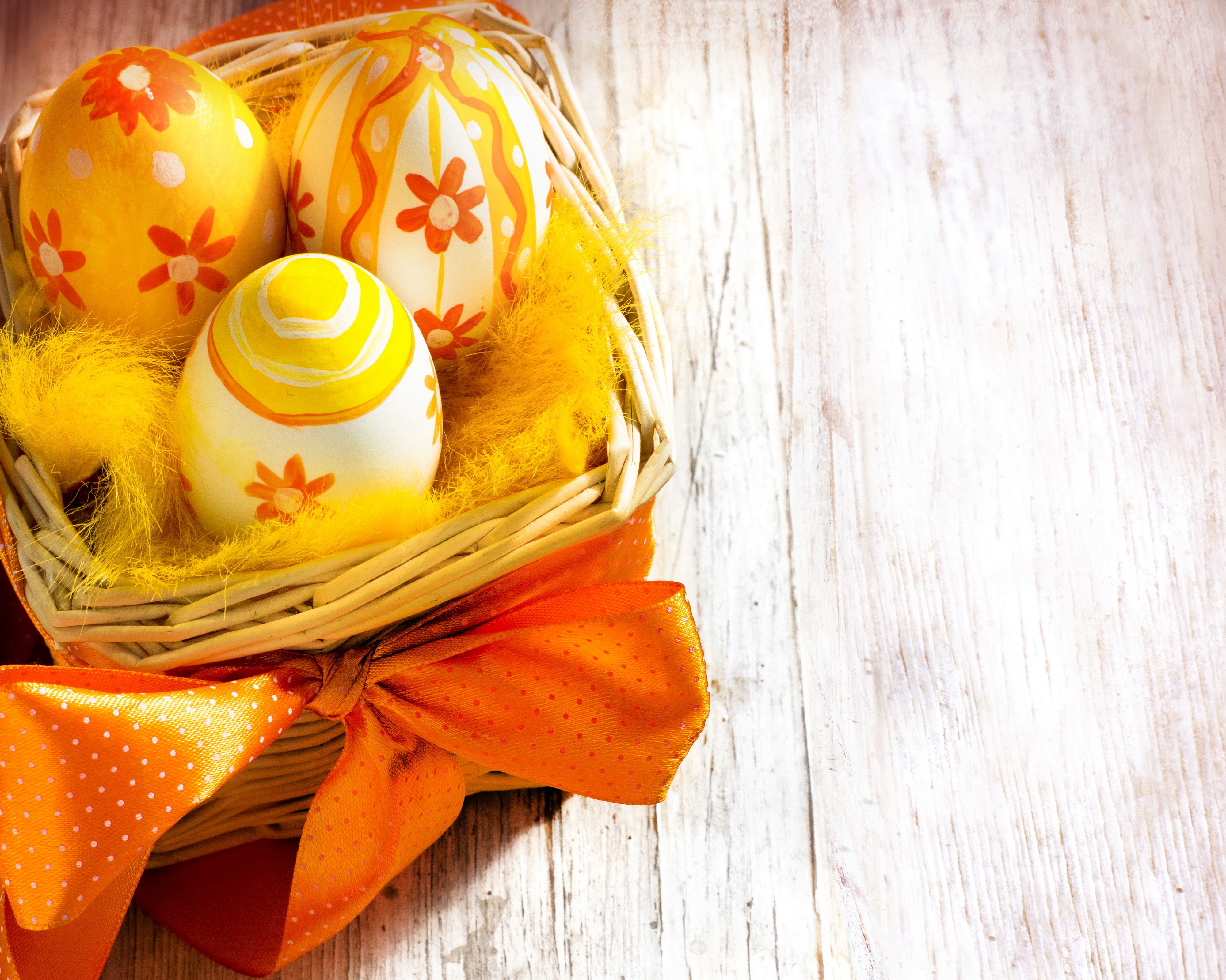 Easter eggs in a wicker basket with orange bow HD Wallpaper