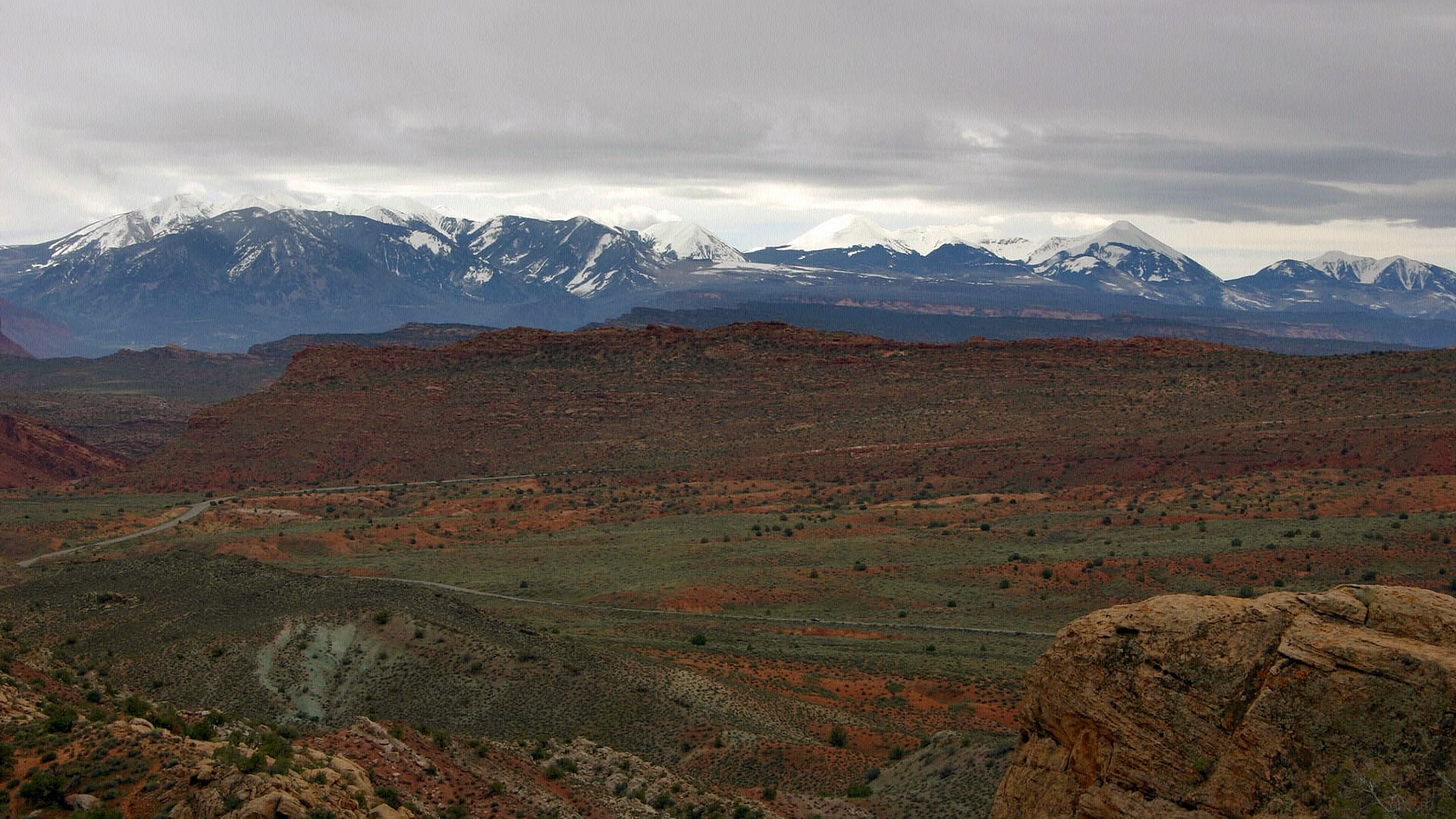 Snow-capped mountains over a desert landscape HD Wallpaper