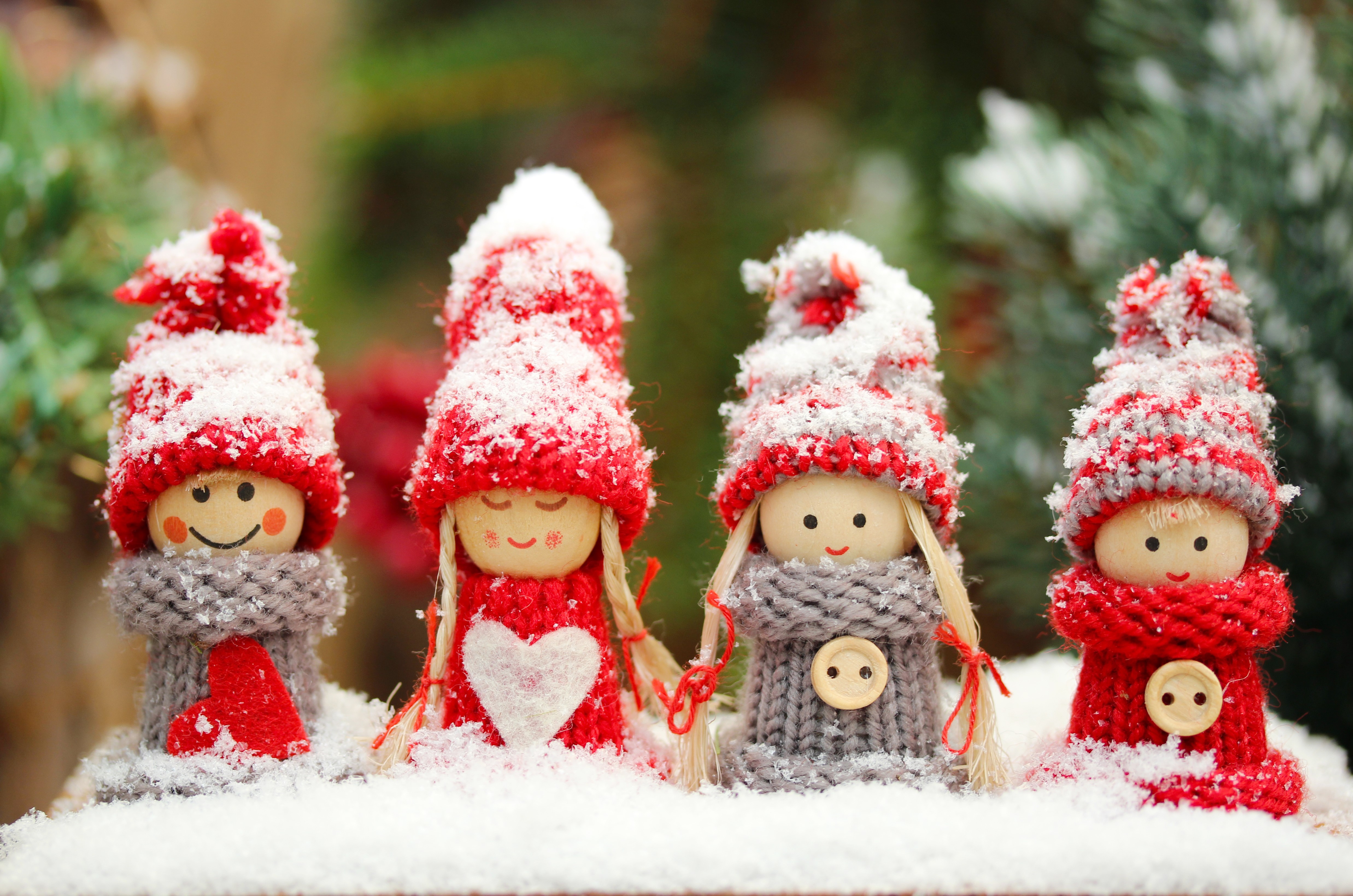 Four snow-covered Christmas gnomes with knitted hats and scarves HD Wallpaper