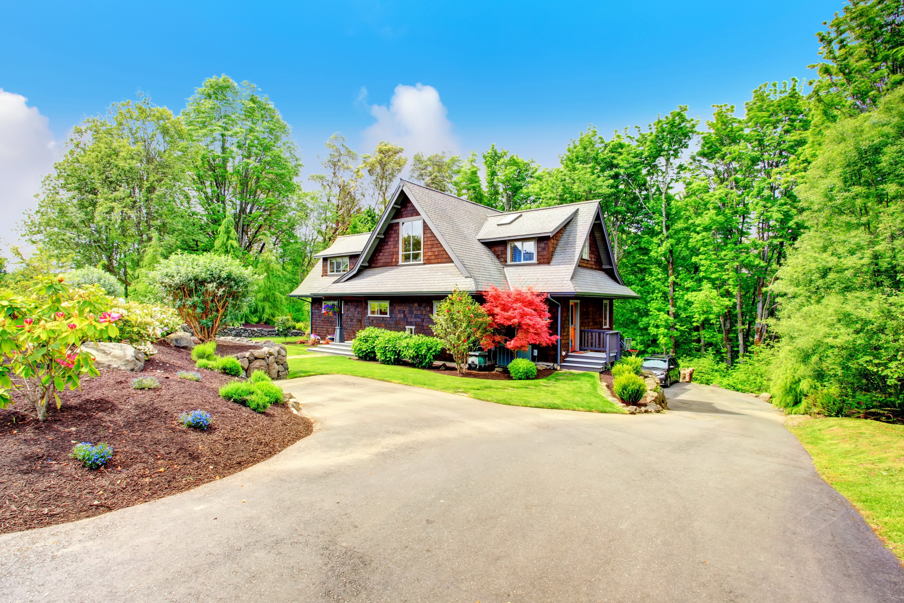 A large wooden house with a driveway and trees HD Wallpaper