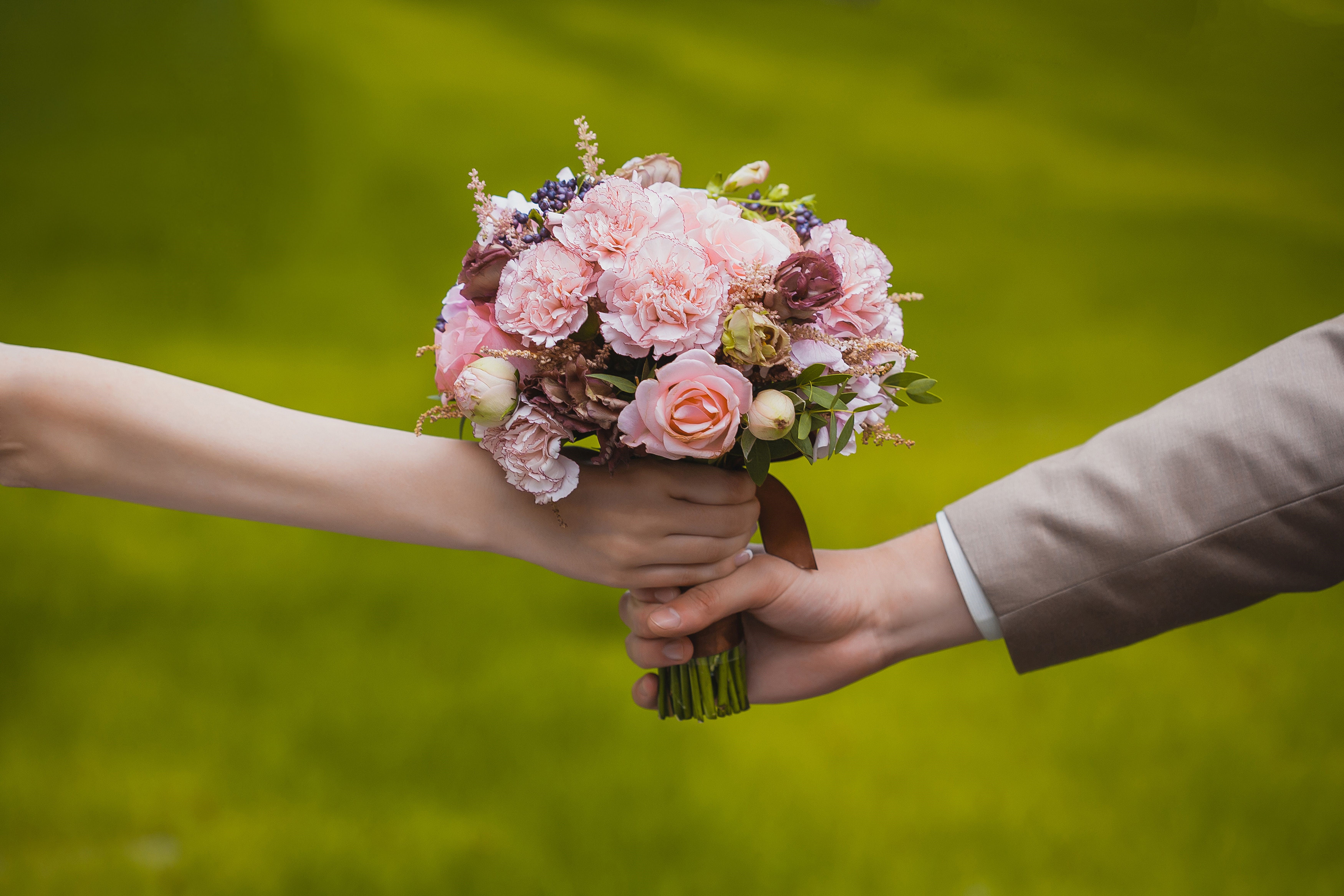 Two hands holding a bouquet of pink flowers HD Wallpaper