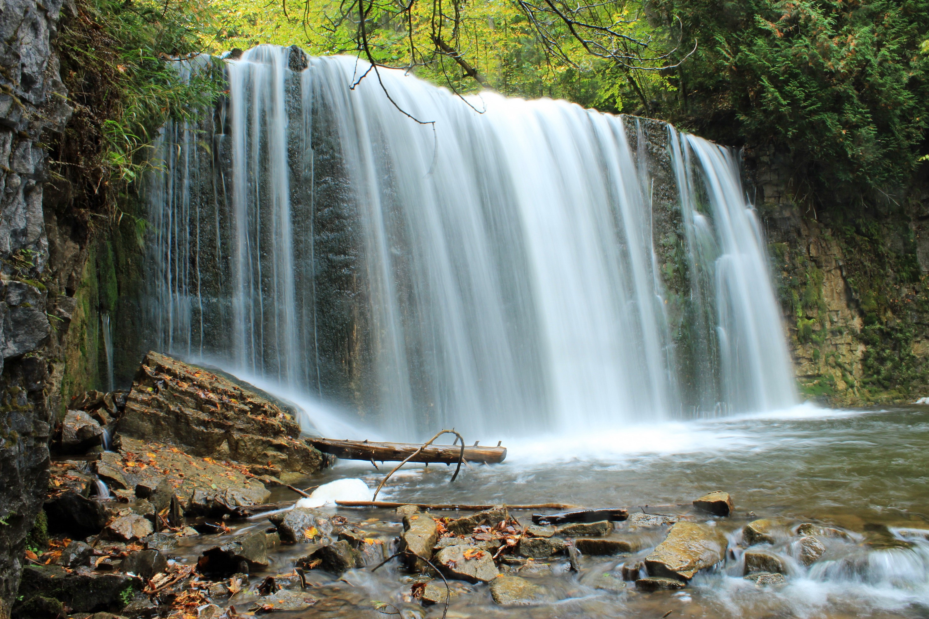 Waterfall over rocks in a forest HD Wallpaper