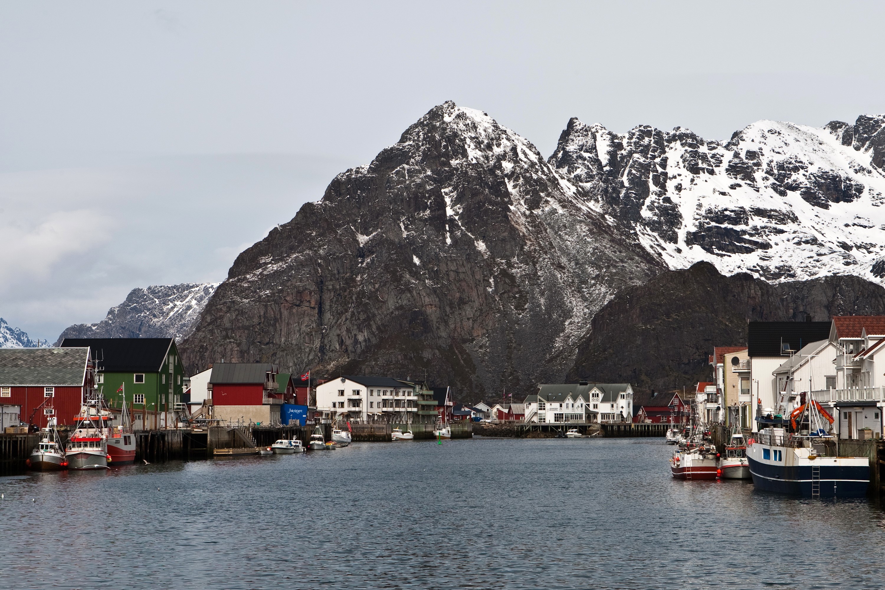 Fishing village with snow-capped mountains in Lofoten, Norway HD Wallpaper