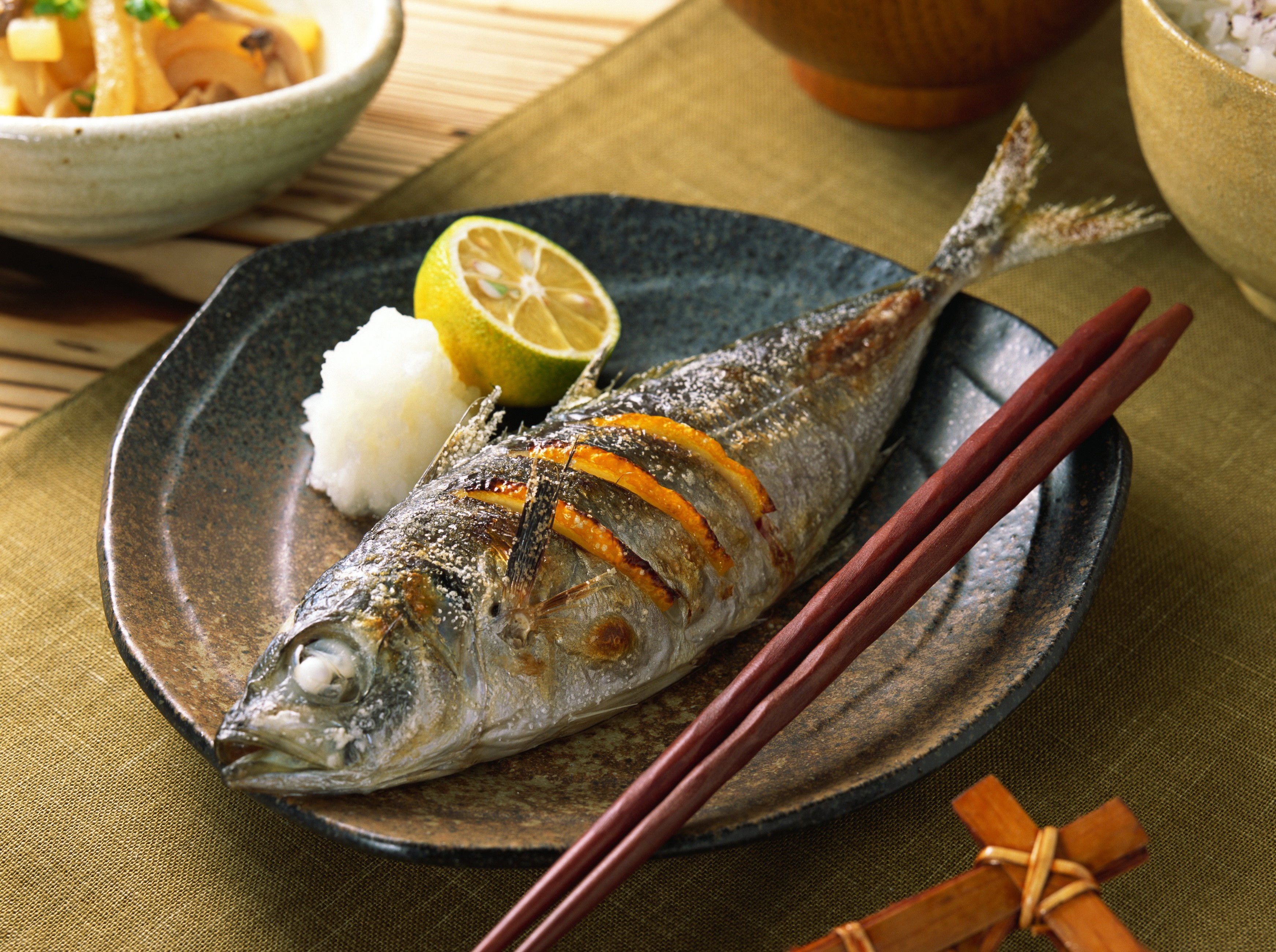 Grilled fish with lemon and grated radish on a plate HD Wallpaper