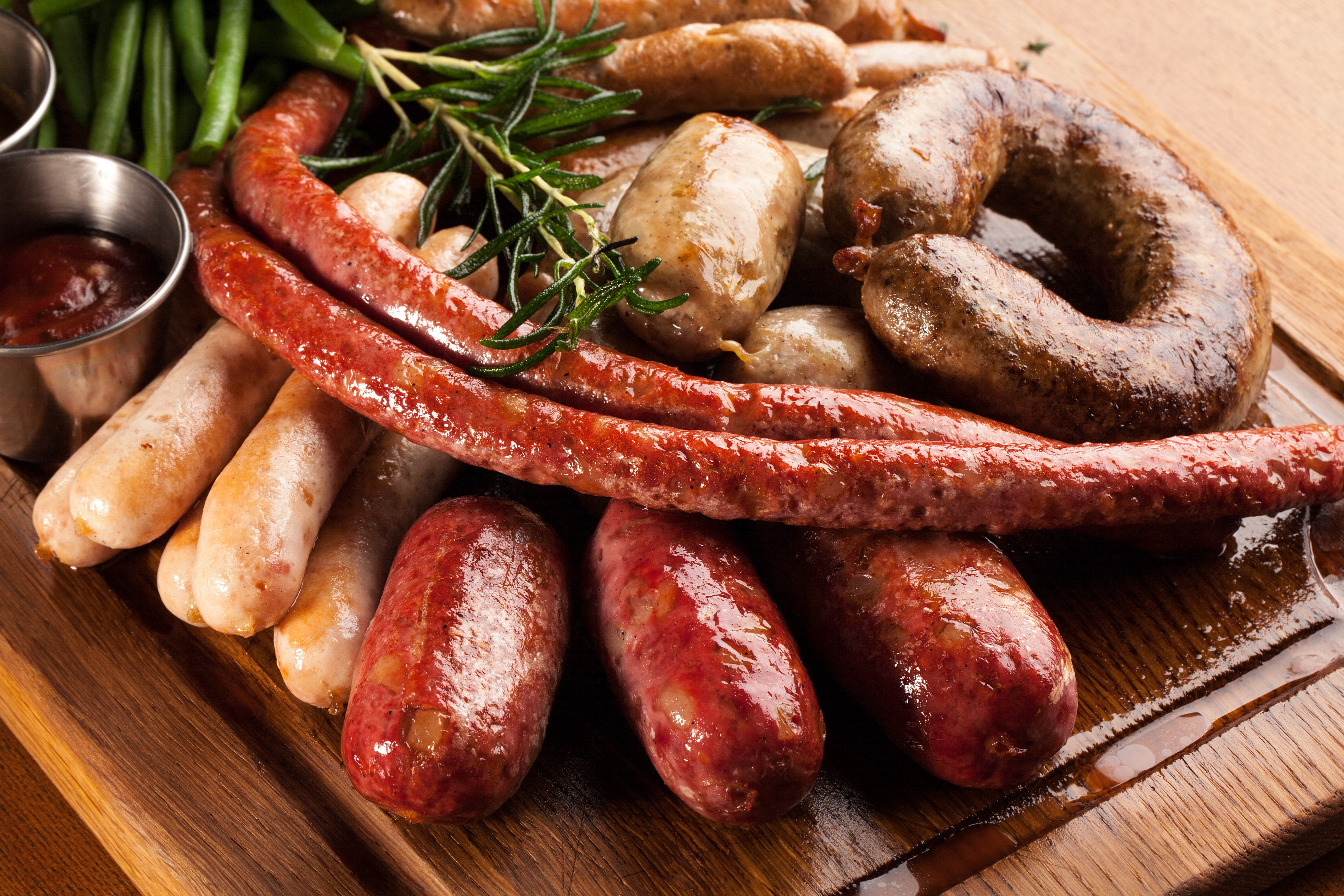 Assortment of Sausages on a Wooden Board HD Wallpaper