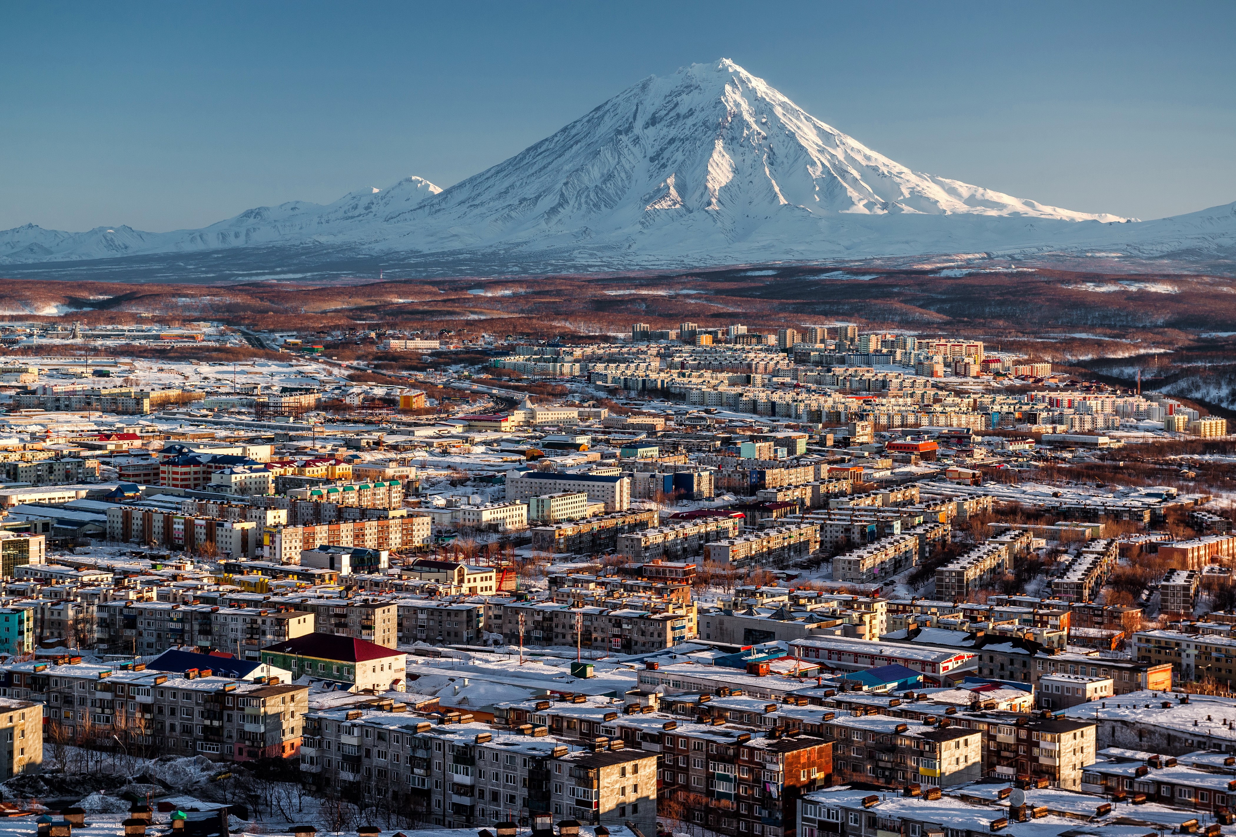 Cityscape with Snow-Capped Volcano in Russia HD Wallpaper