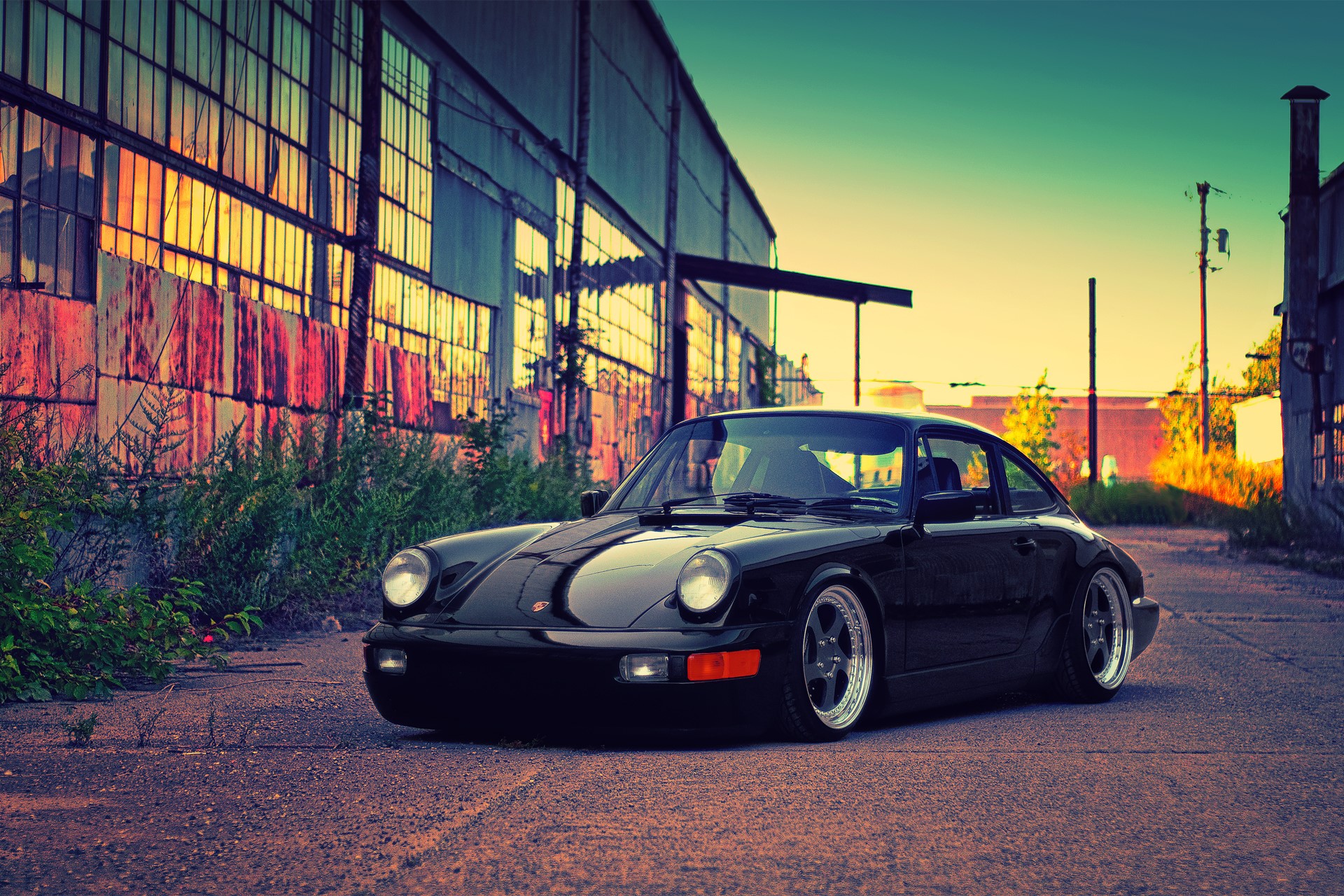 Black Porsche 911 parked in front of an abandoned building HD Wallpaper