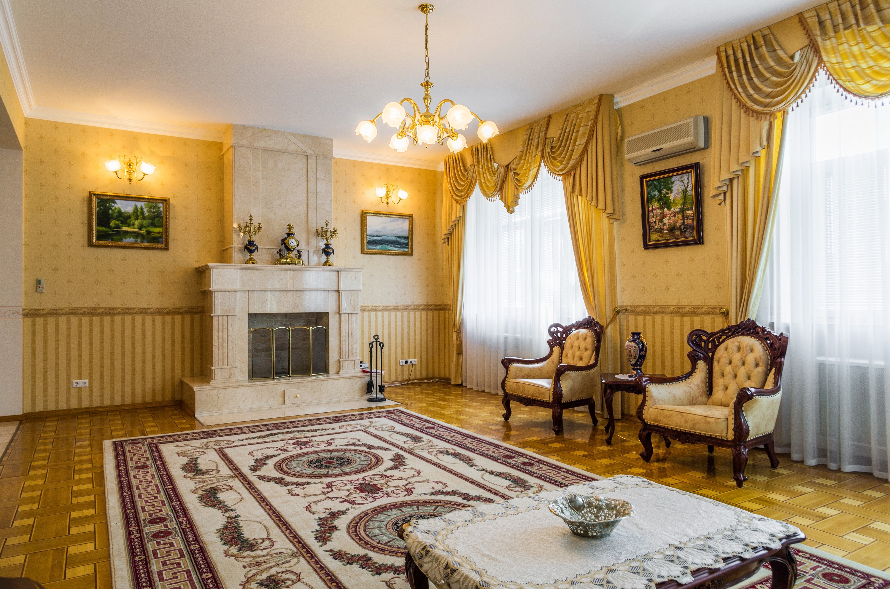 Living room with fireplace, armchairs, and chandelier HD Wallpaper