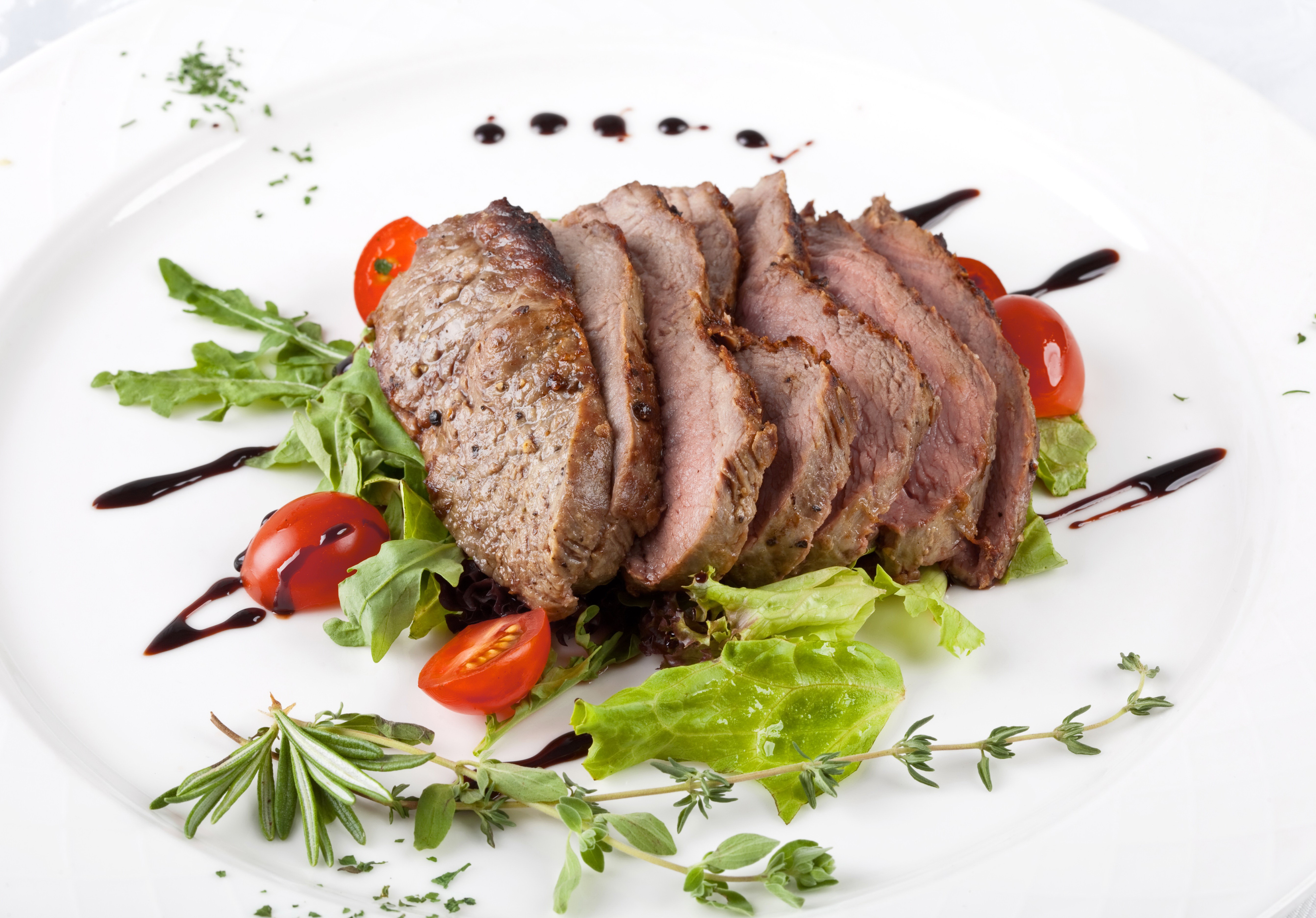 Sliced meat with tomatoes and greens on a plate HD Wallpaper