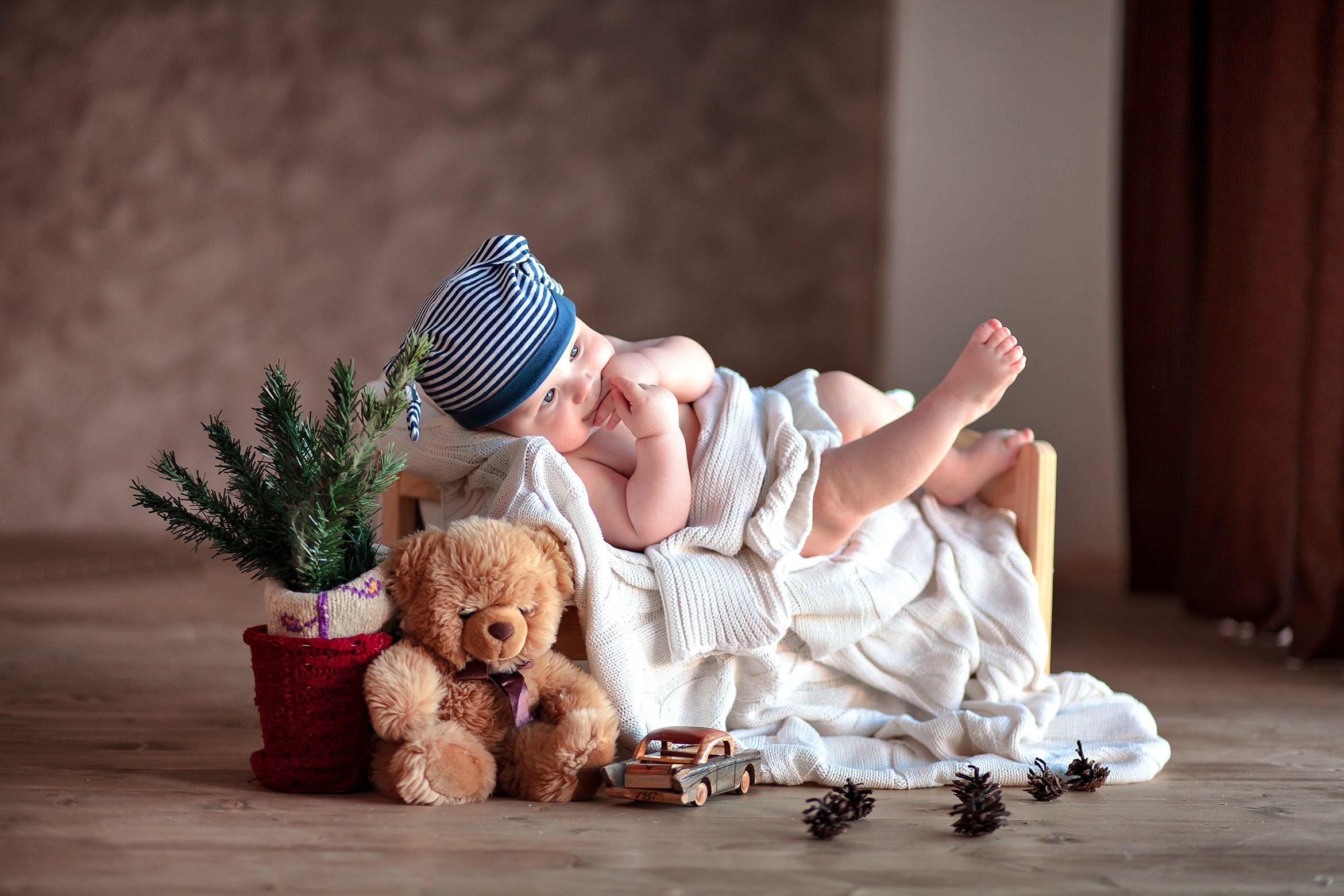 Baby in striped hat with teddy bear and Christmas tree HD Wallpaper