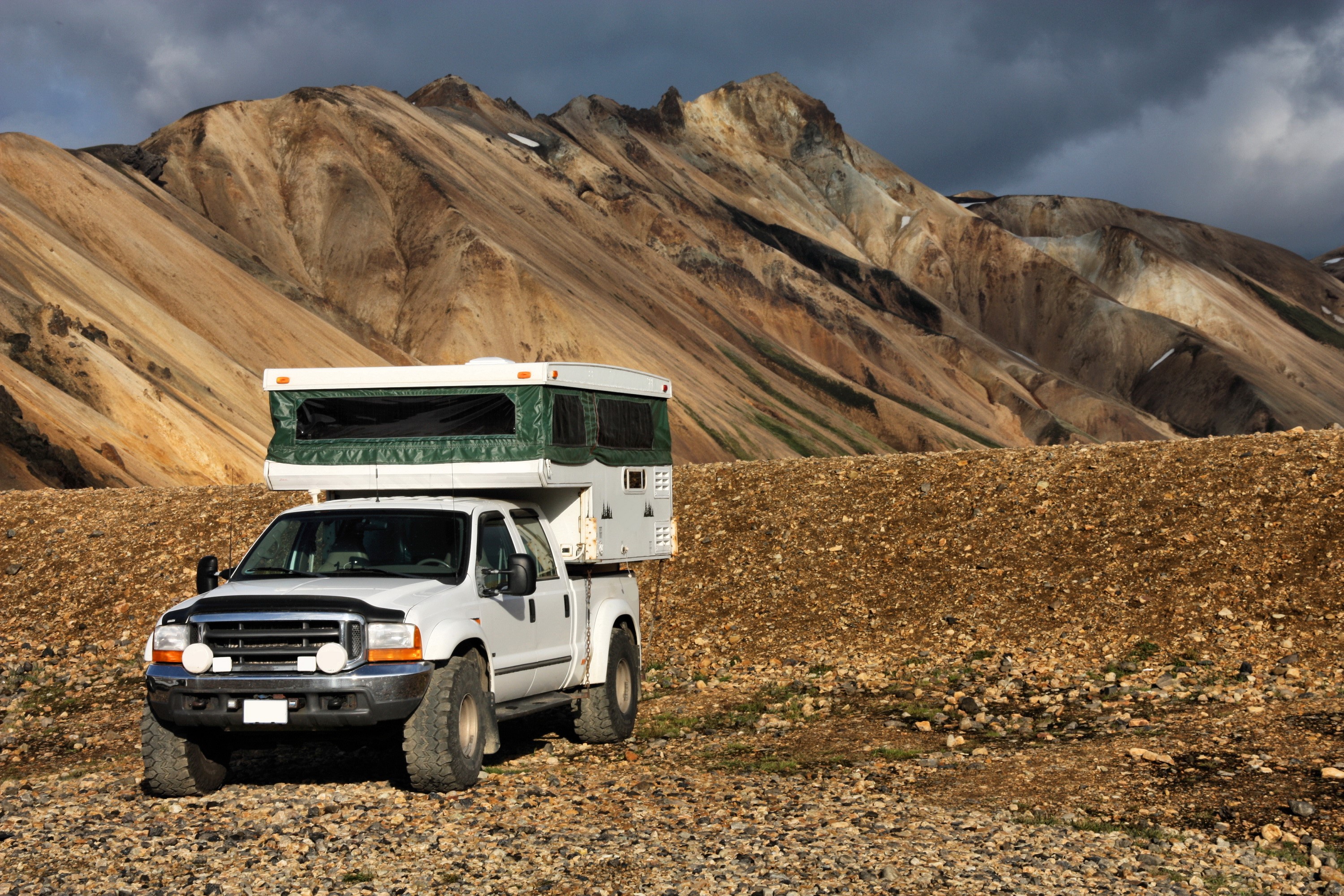 White pickup truck with camper in mountains HD Wallpaper