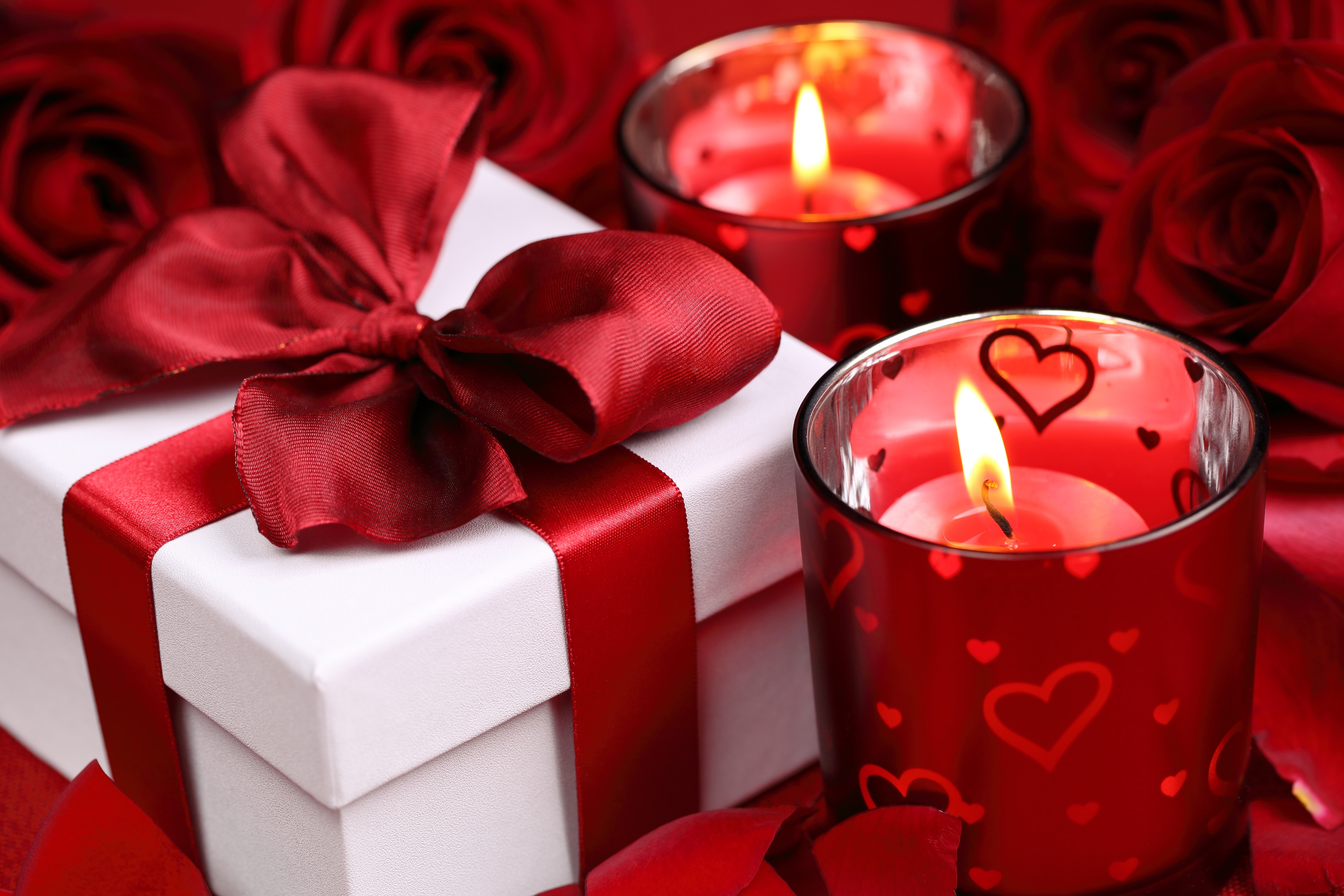 Gift box with red ribbon and candles near roses HD Wallpaper