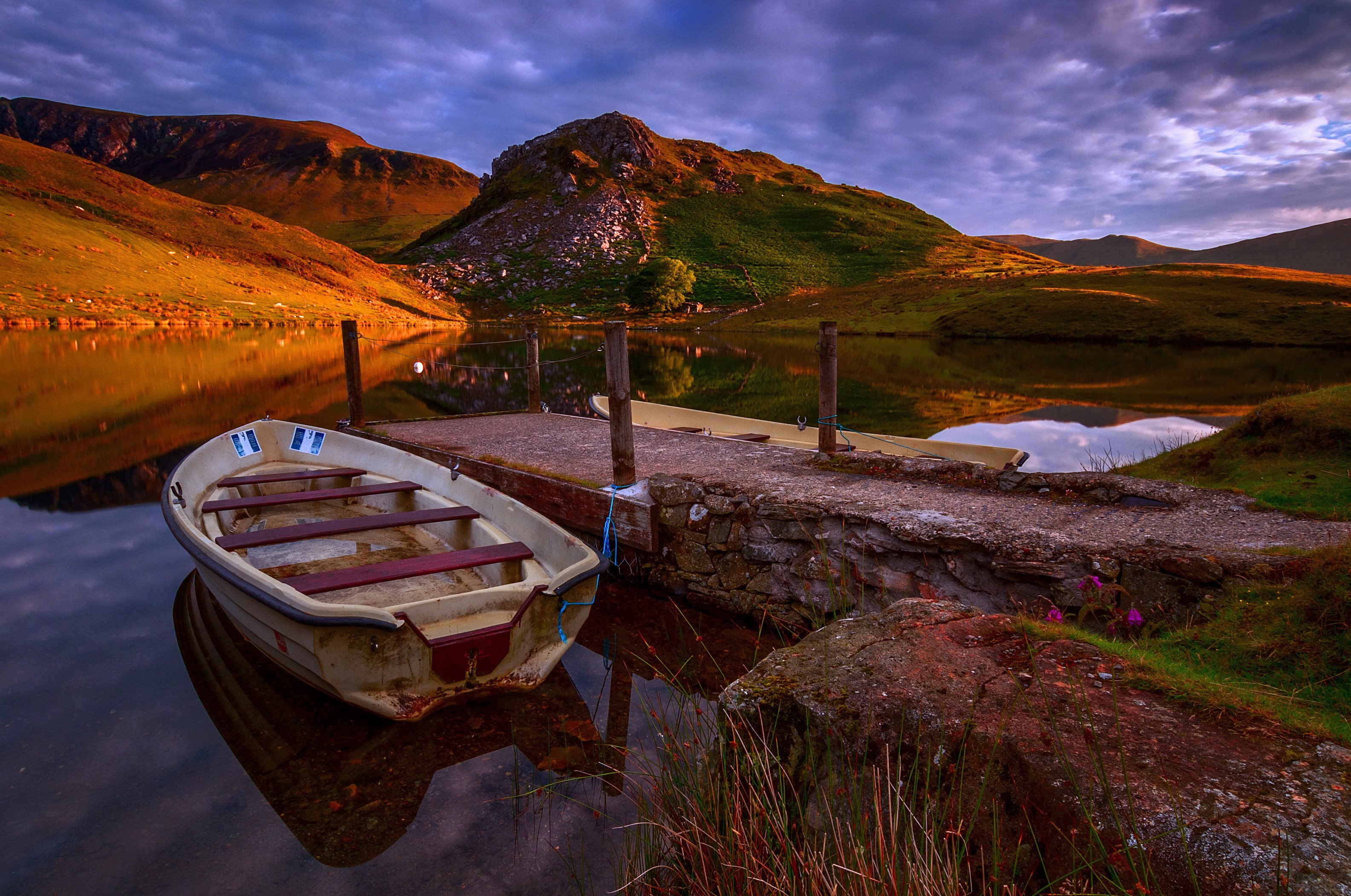Boats docked on a lake with mountains at sunset HD Wallpaper