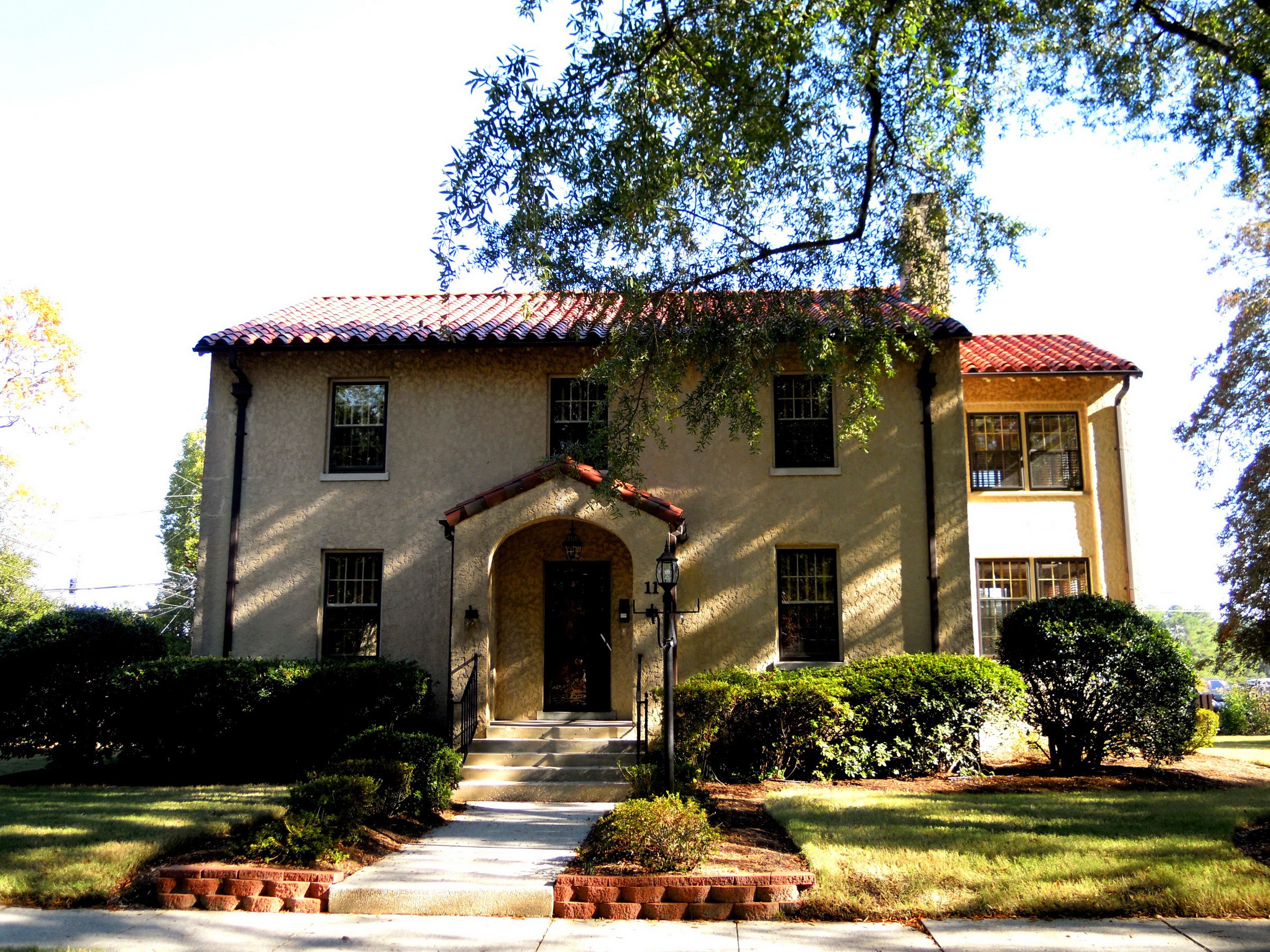 Spanish-style house with red tile roof and manicured lawn HD Wallpaper