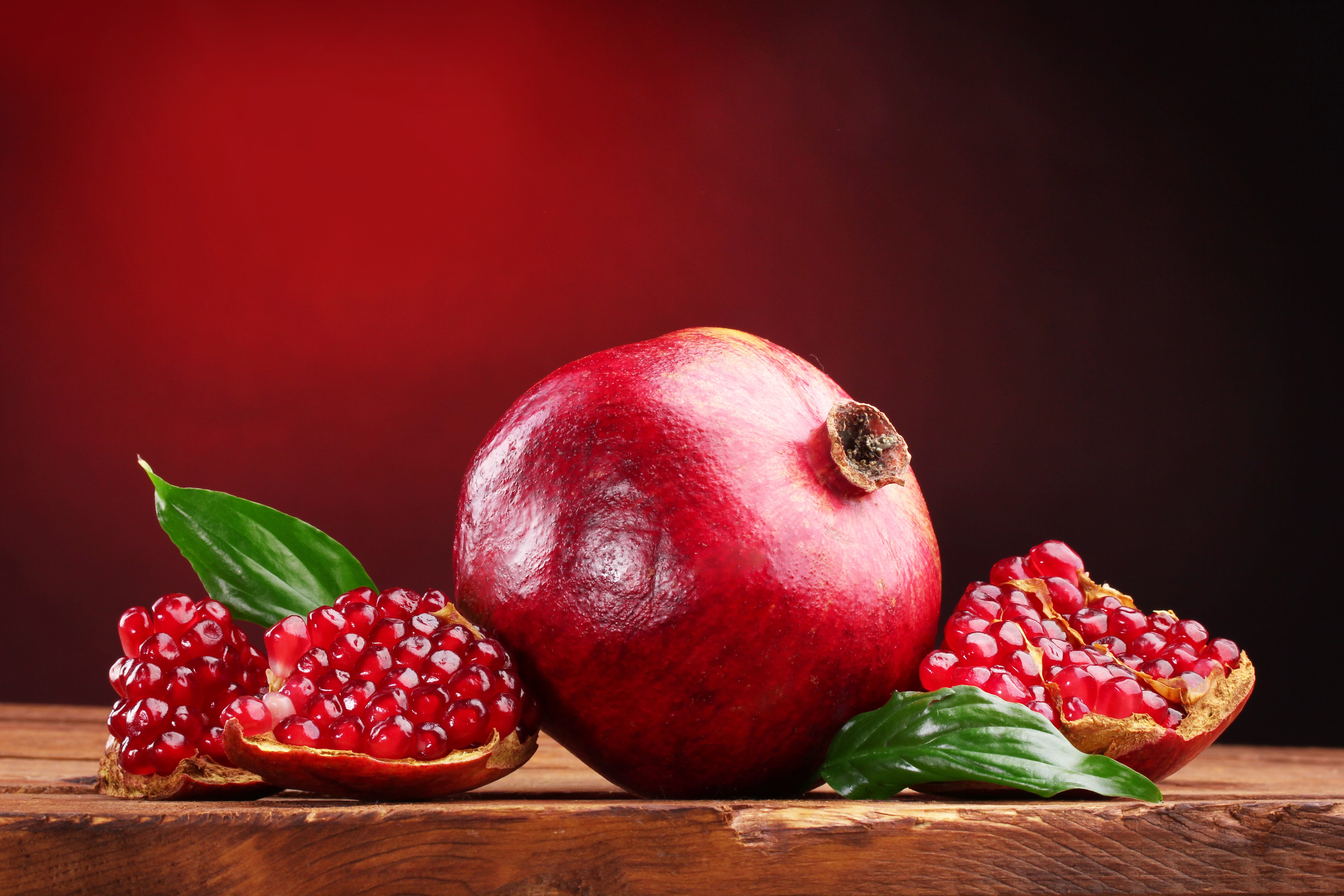 Pomegranates on a wooden surface HD Wallpaper