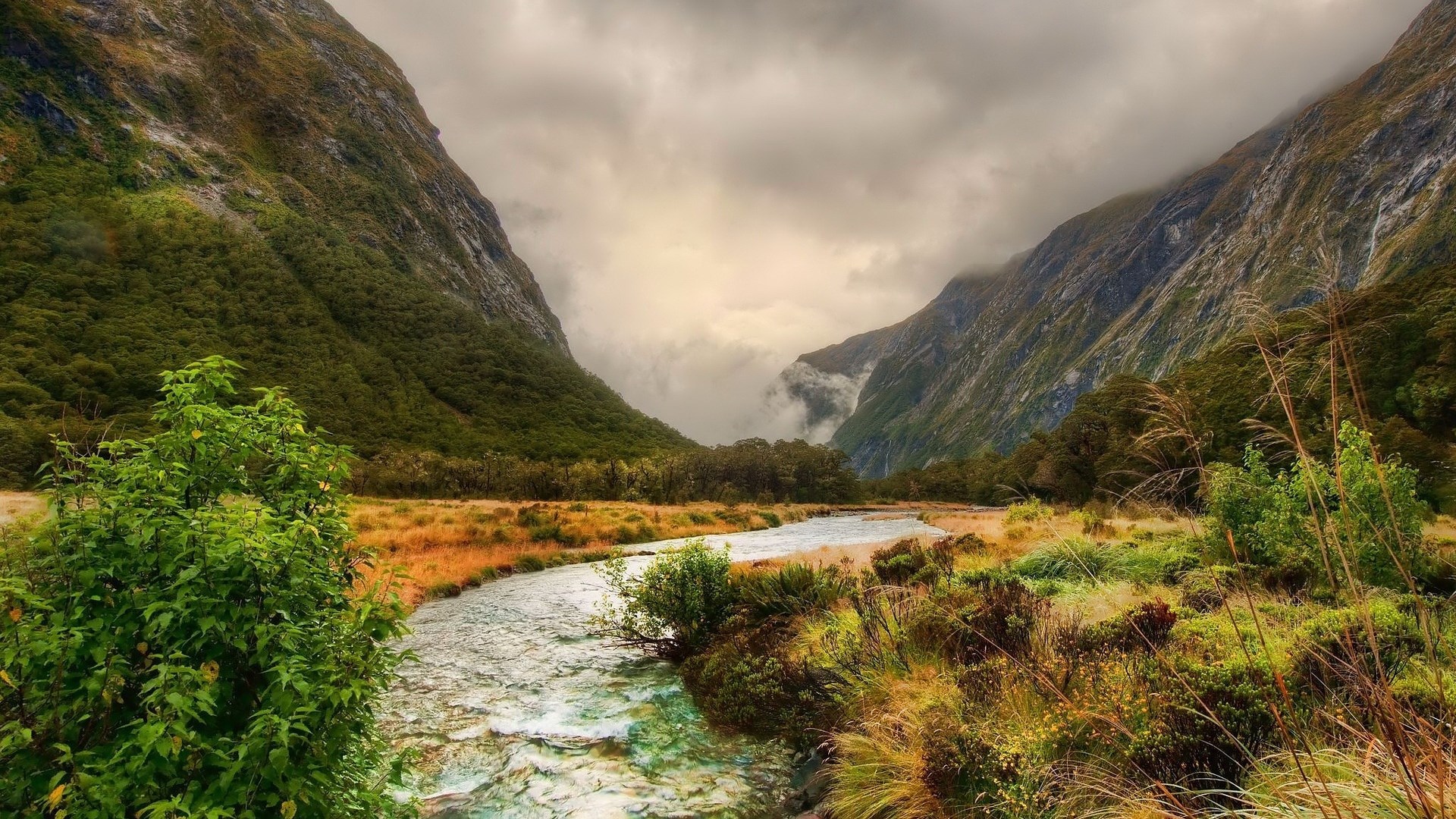 River flowing through a valley with mountains HD Wallpaper