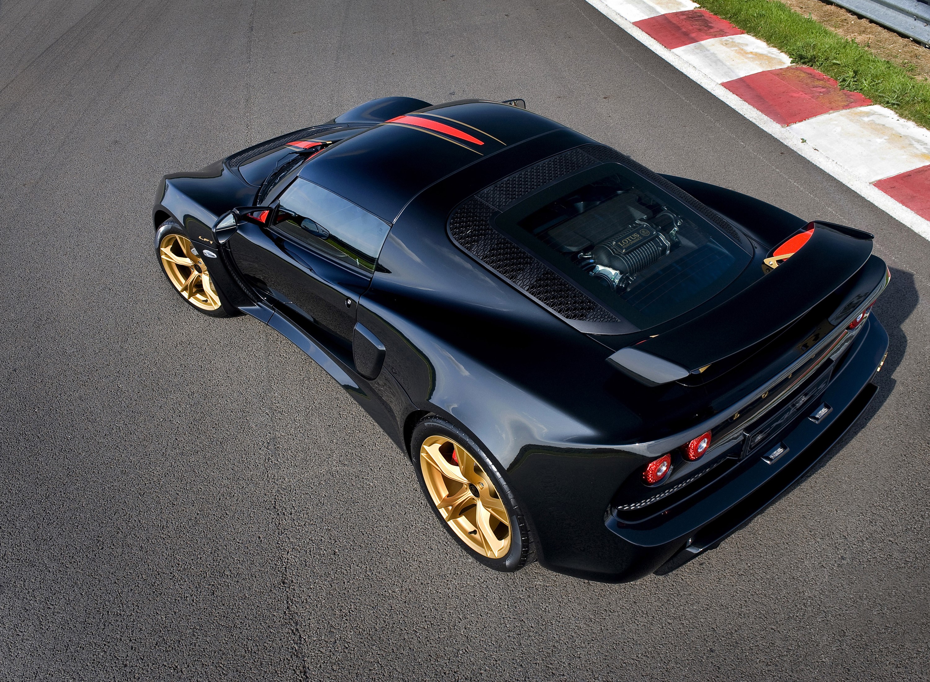 Black Lotus Exige LF1 with gold wheels on a track HD Wallpaper
