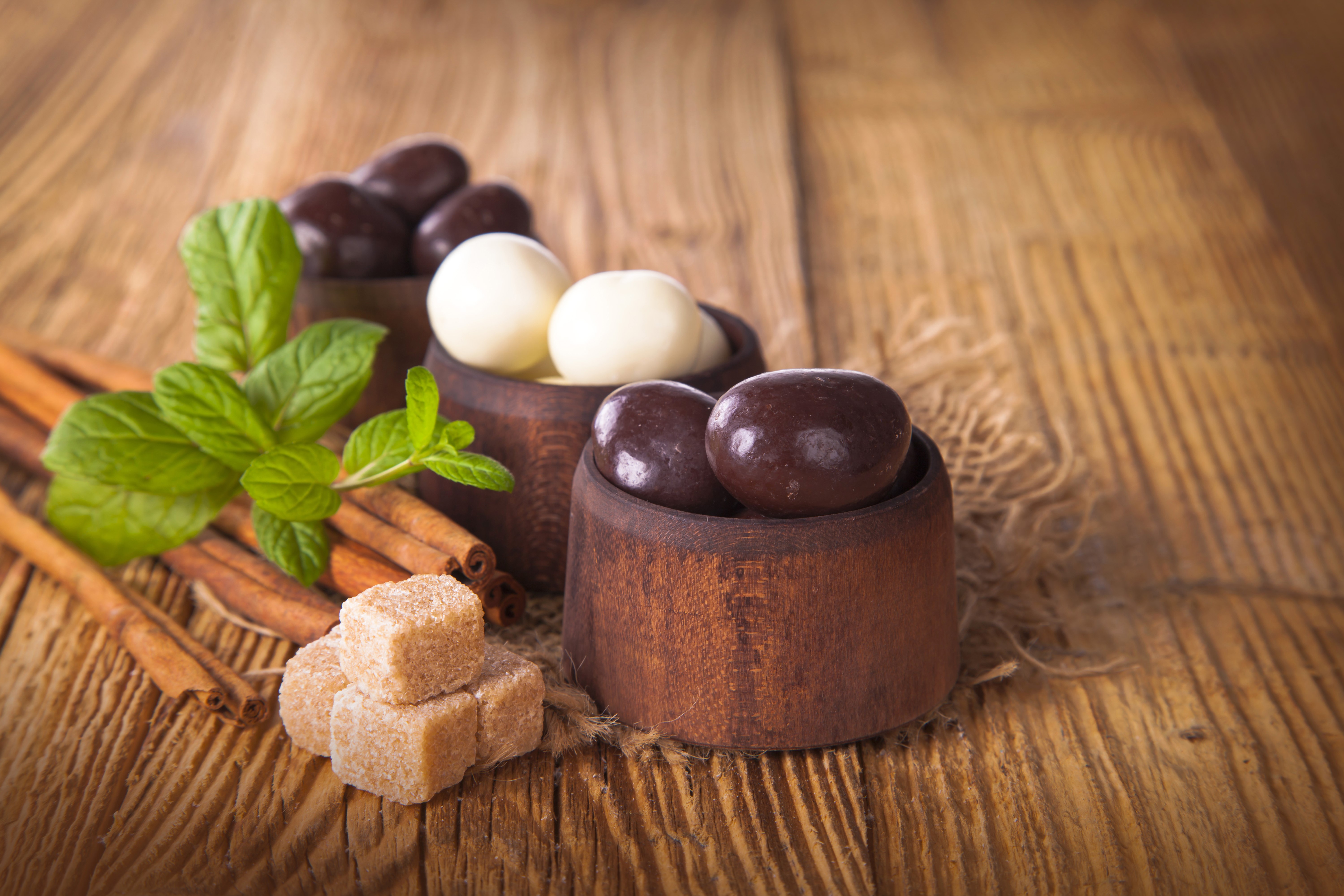 Sweets and candies on a wooden table with cinnamon and mint HD Wallpaper