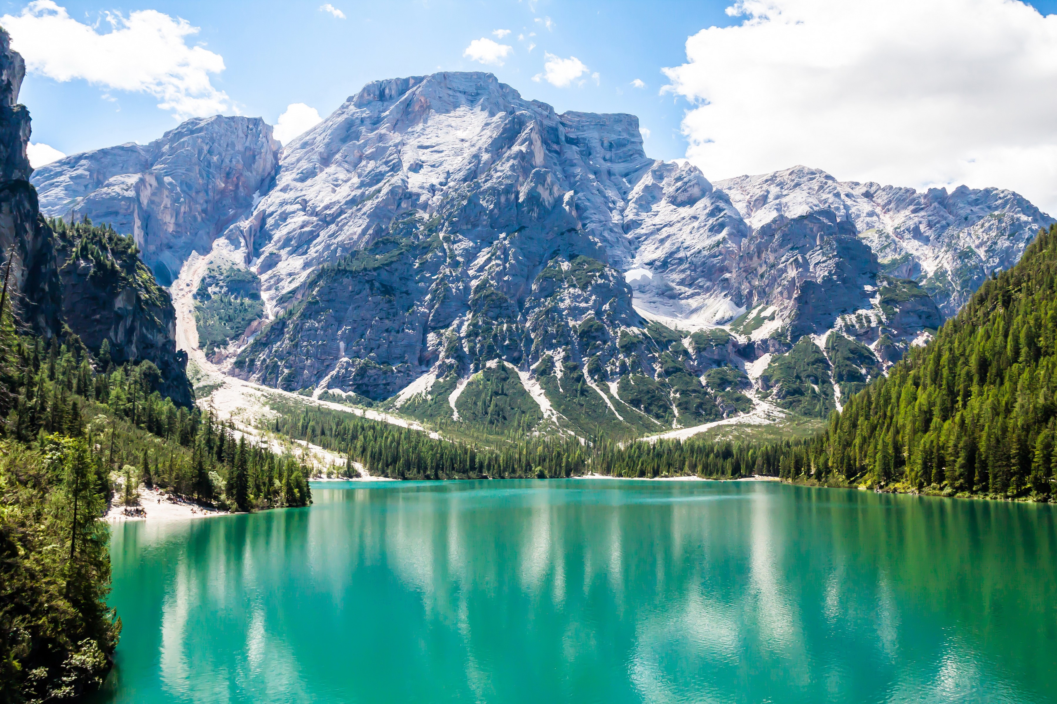 Turquoise lake in front of majestic mountains and green forest HD Wallpaper
