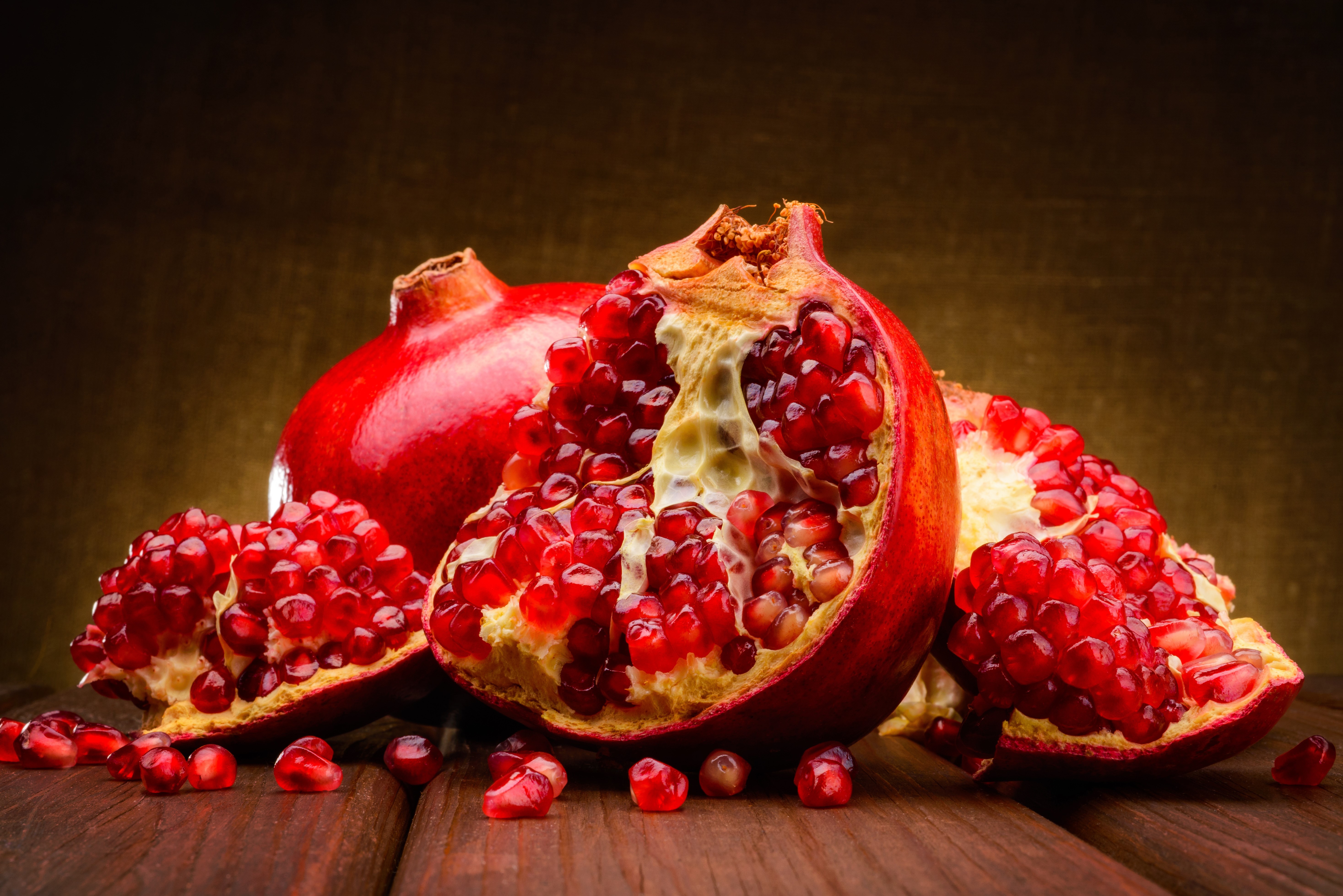 Pomegranate closeup on wooden table HD Wallpaper