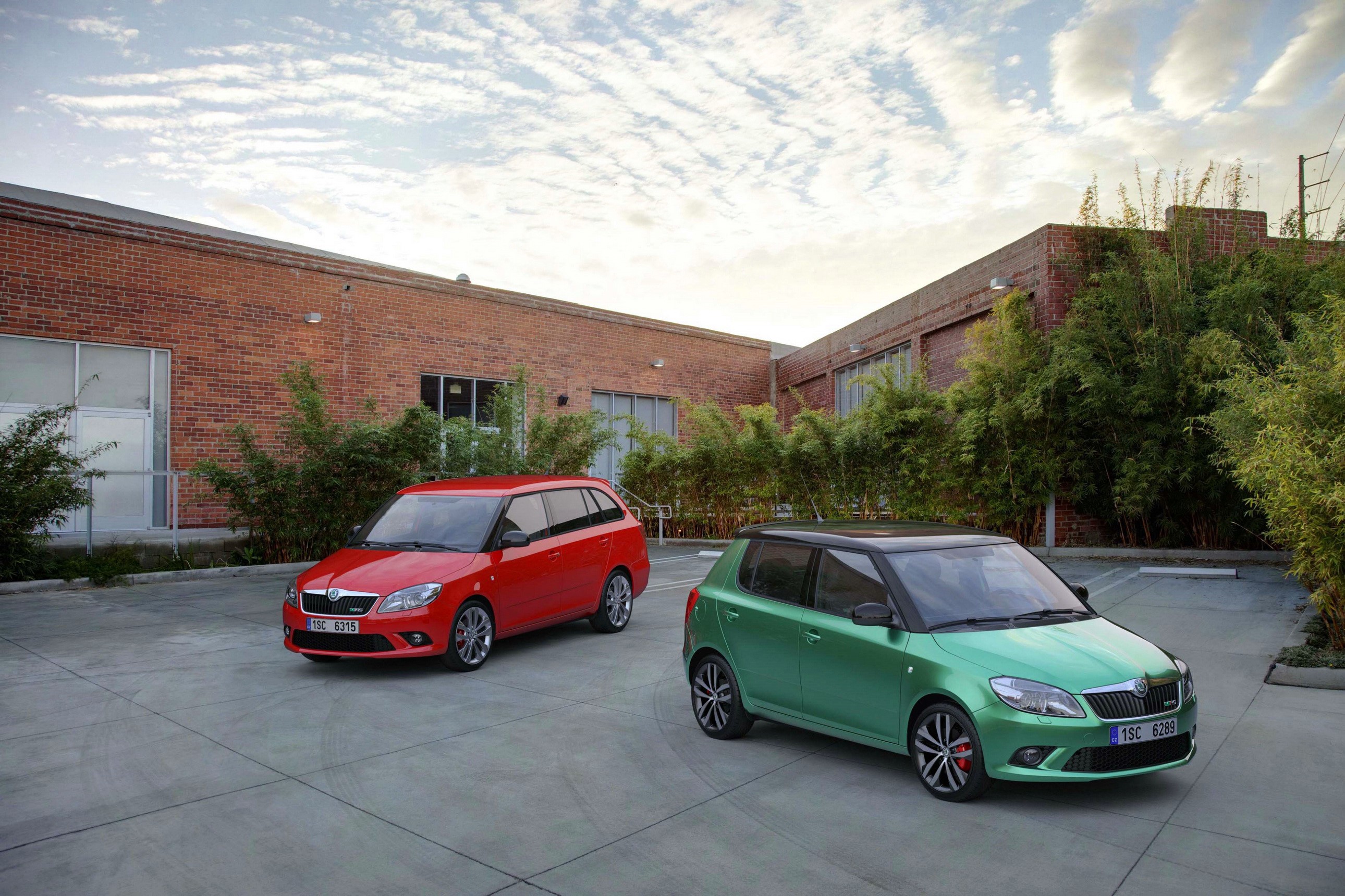 Two Skoda Fabia RS cars parked outside a brick building HD Wallpaper