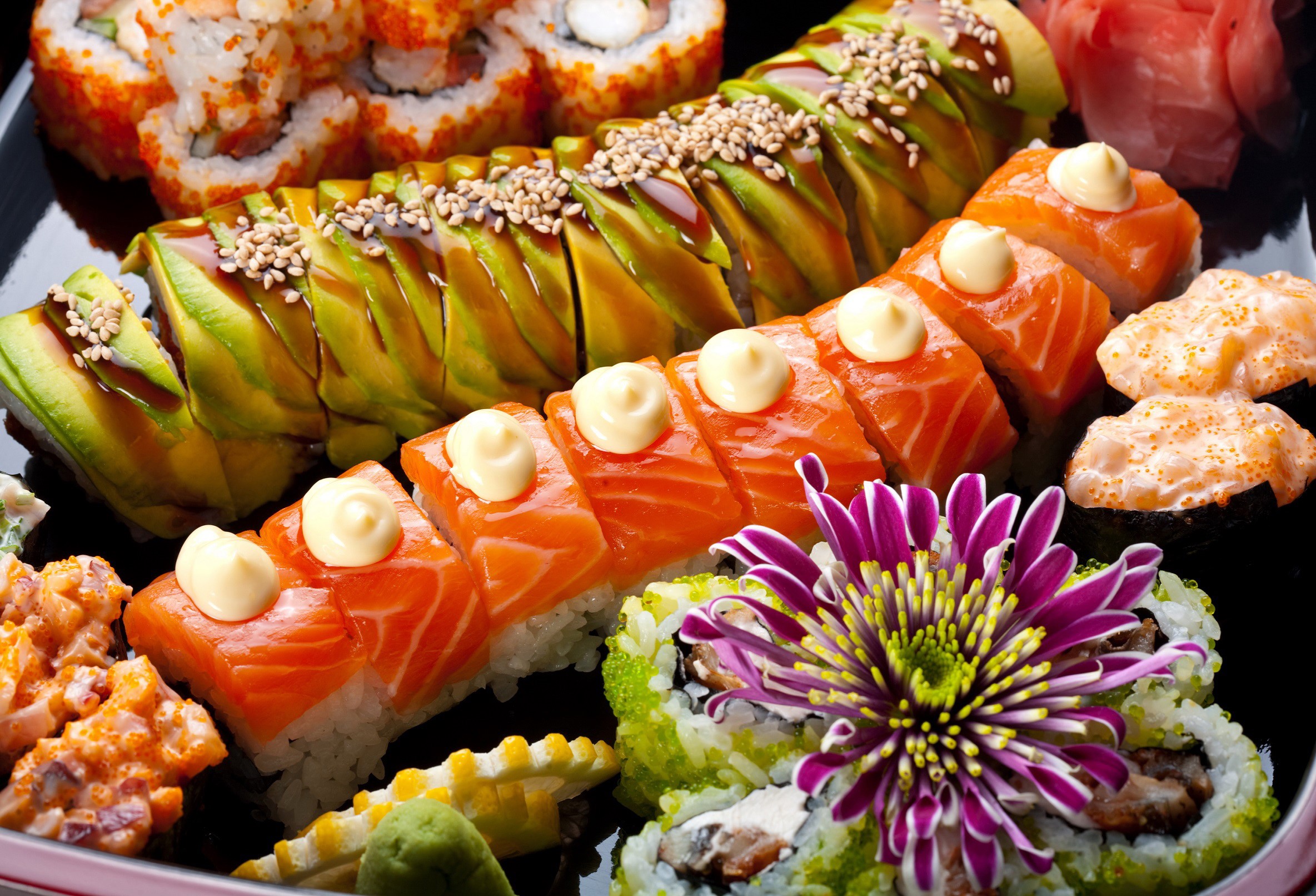 Assortment of sushi and sashimi on a black plate HD Wallpaper