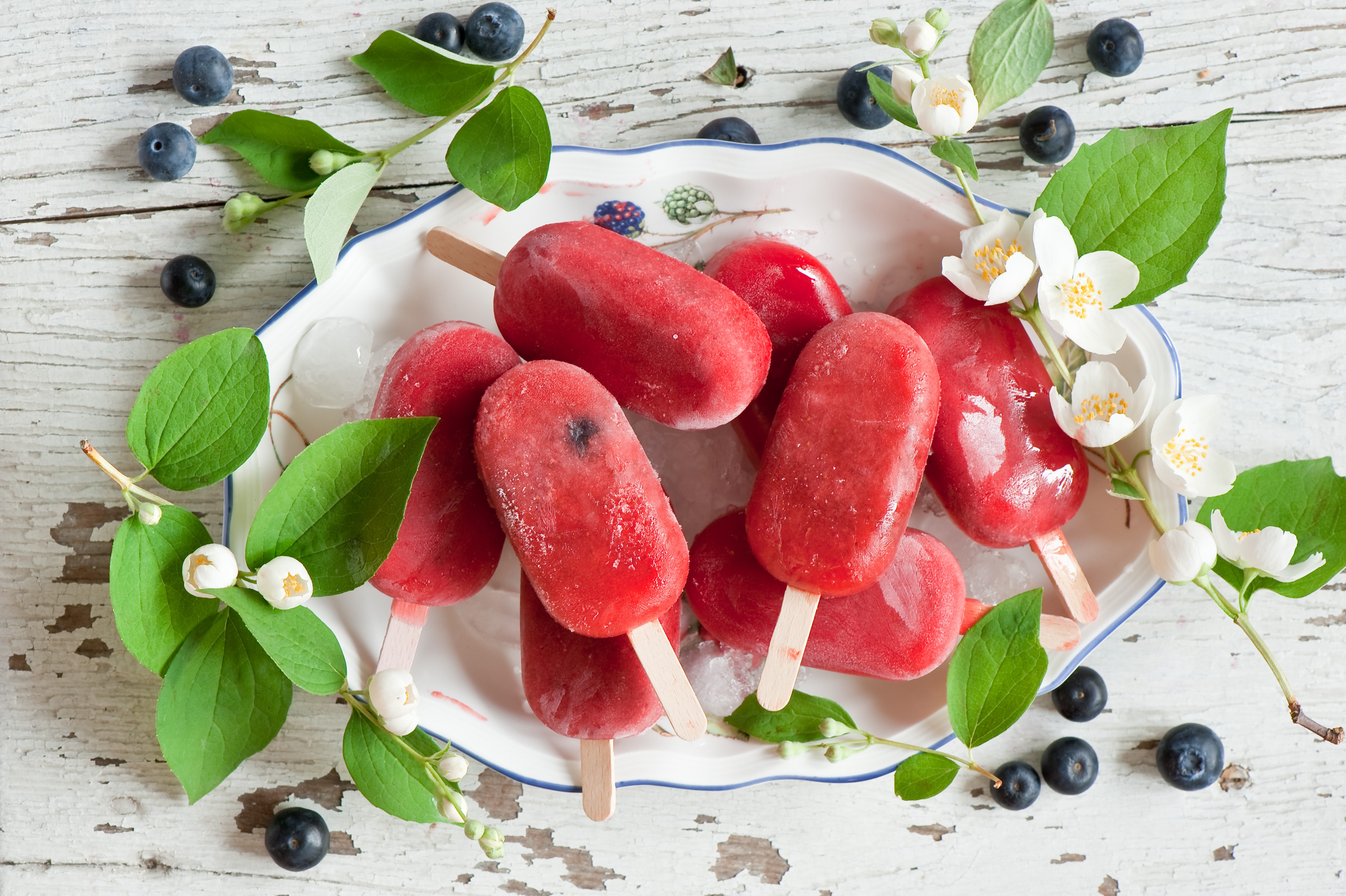 Red popsicles with blueberries and jasmine on a plate HD Wallpaper