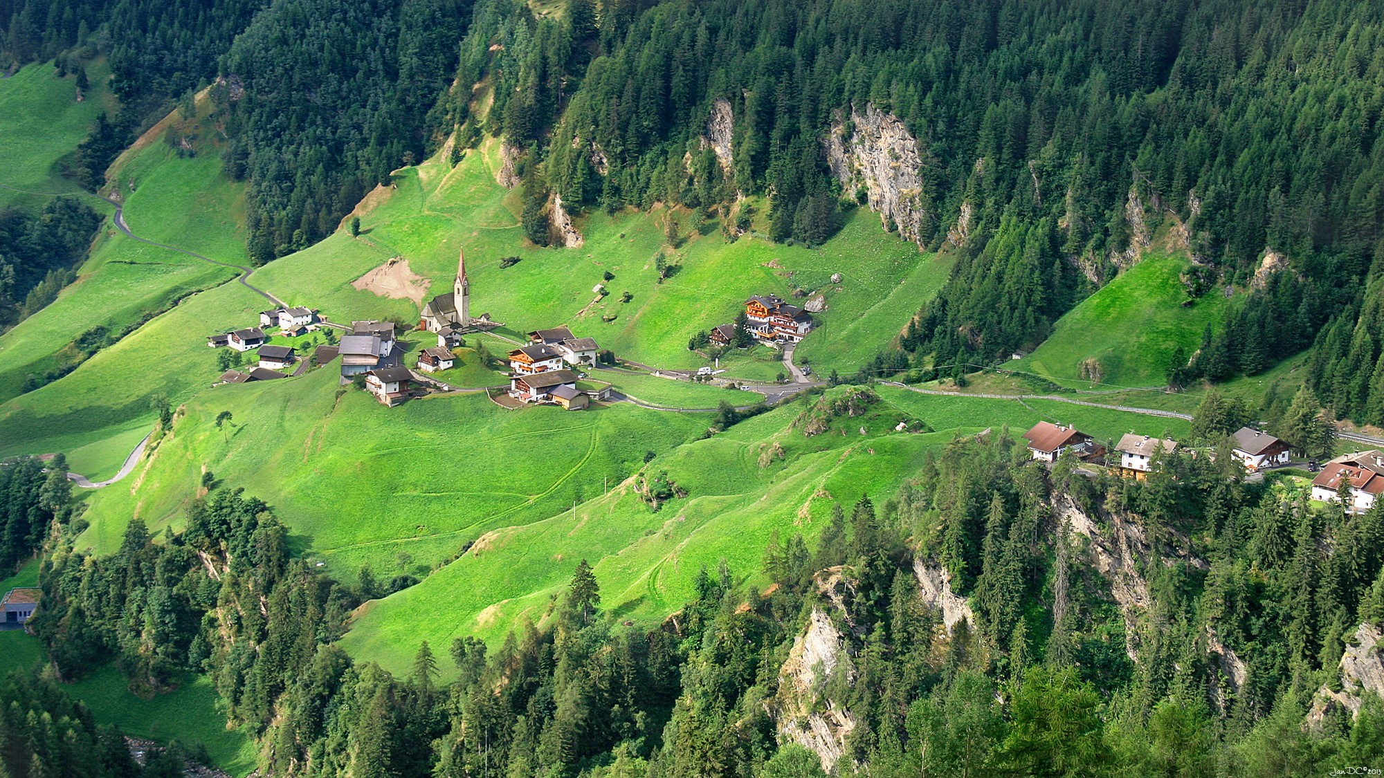 Houses and church in a green mountain valley in Trentino, Italy HD Wallpaper