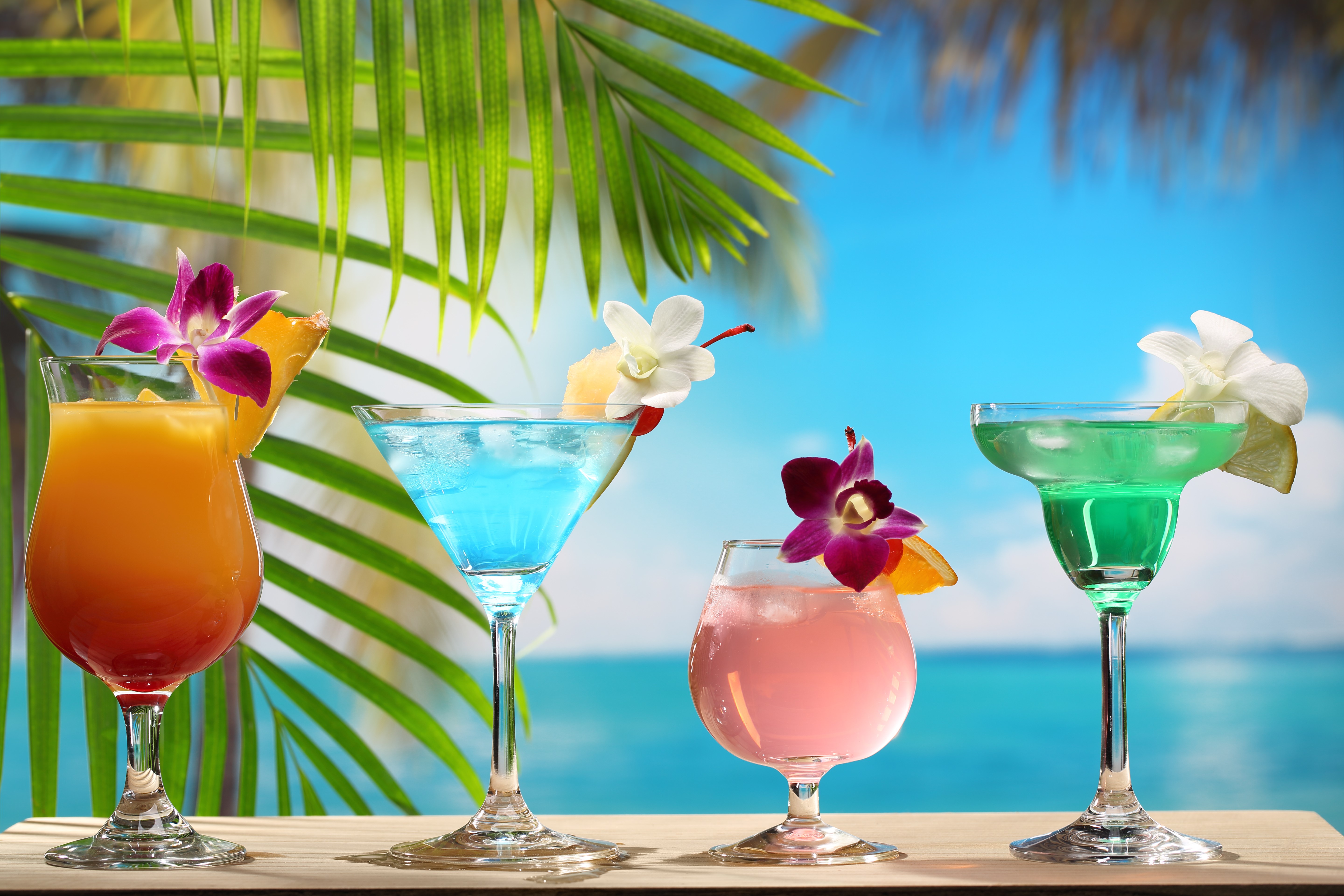 Four colorful tropical cocktails on a beach background HD Wallpaper
