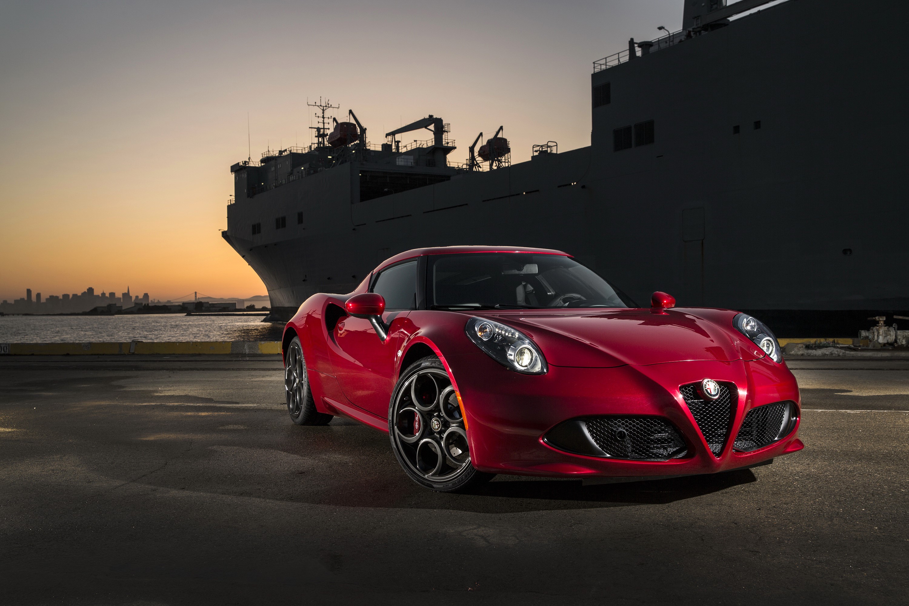 Red Alfa Romeo 4C parked by a ship at sunset HD Wallpaper