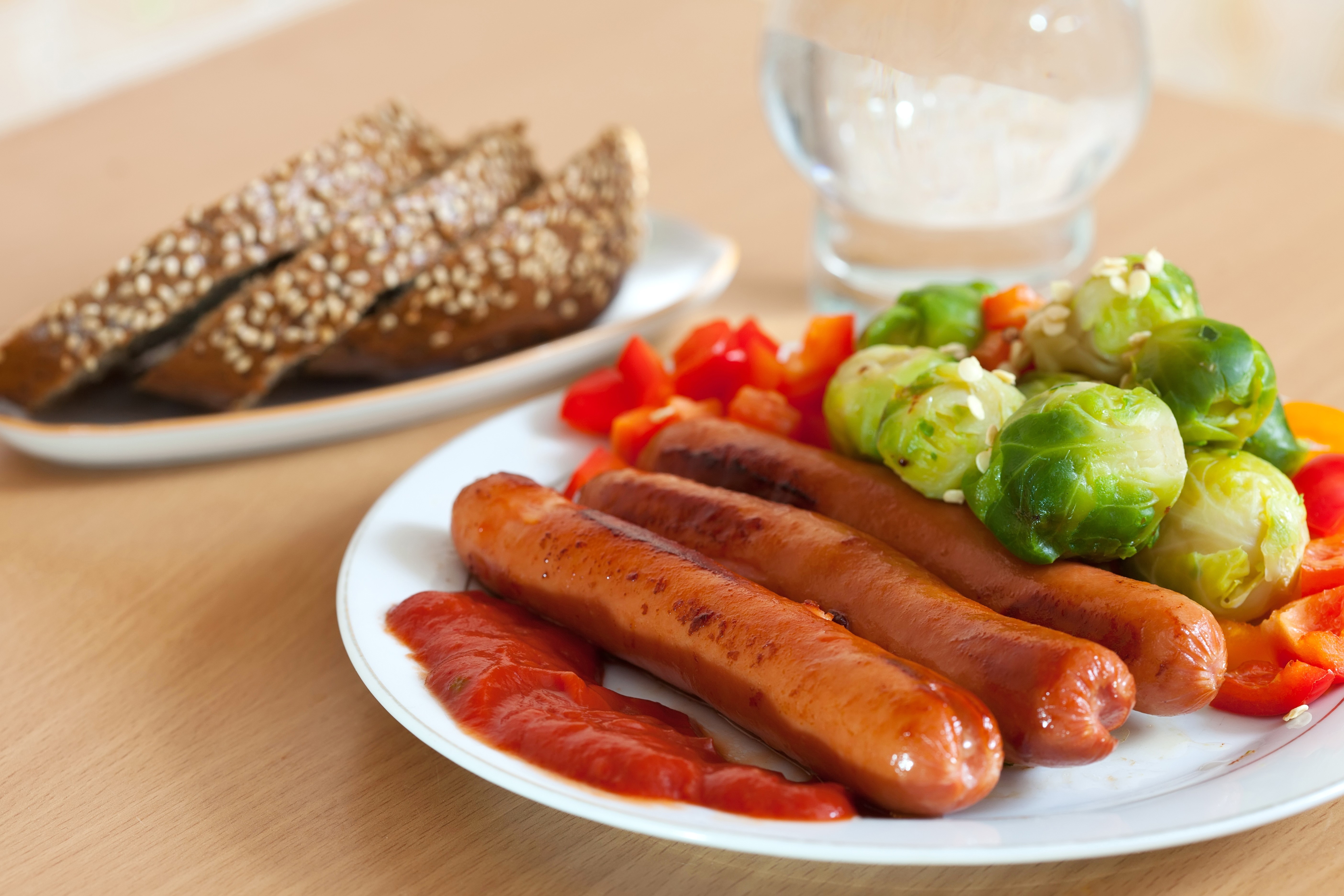 Sausages with Brussels sprouts, bell peppers, and bread HD Wallpaper