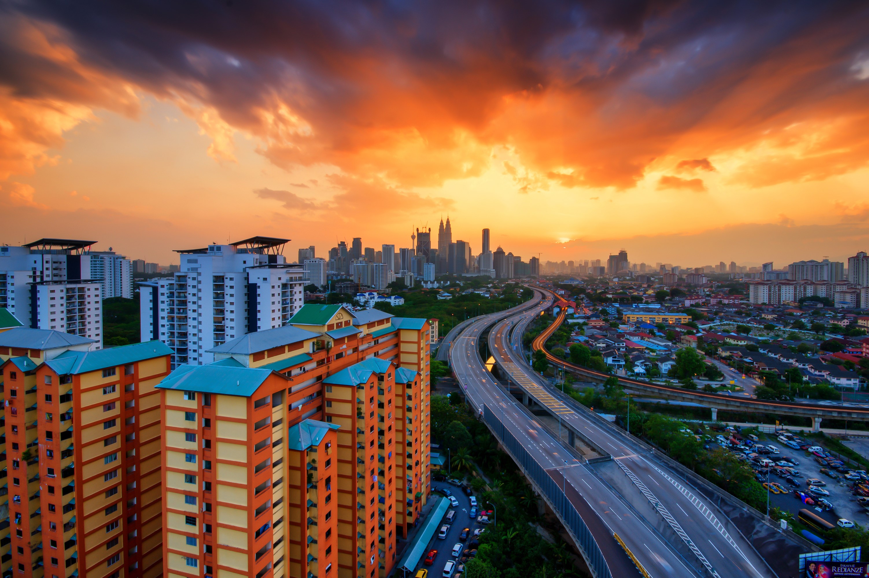 Kuala Lumpur cityscape with highway and apartment buildings at sunset HD Wallpaper