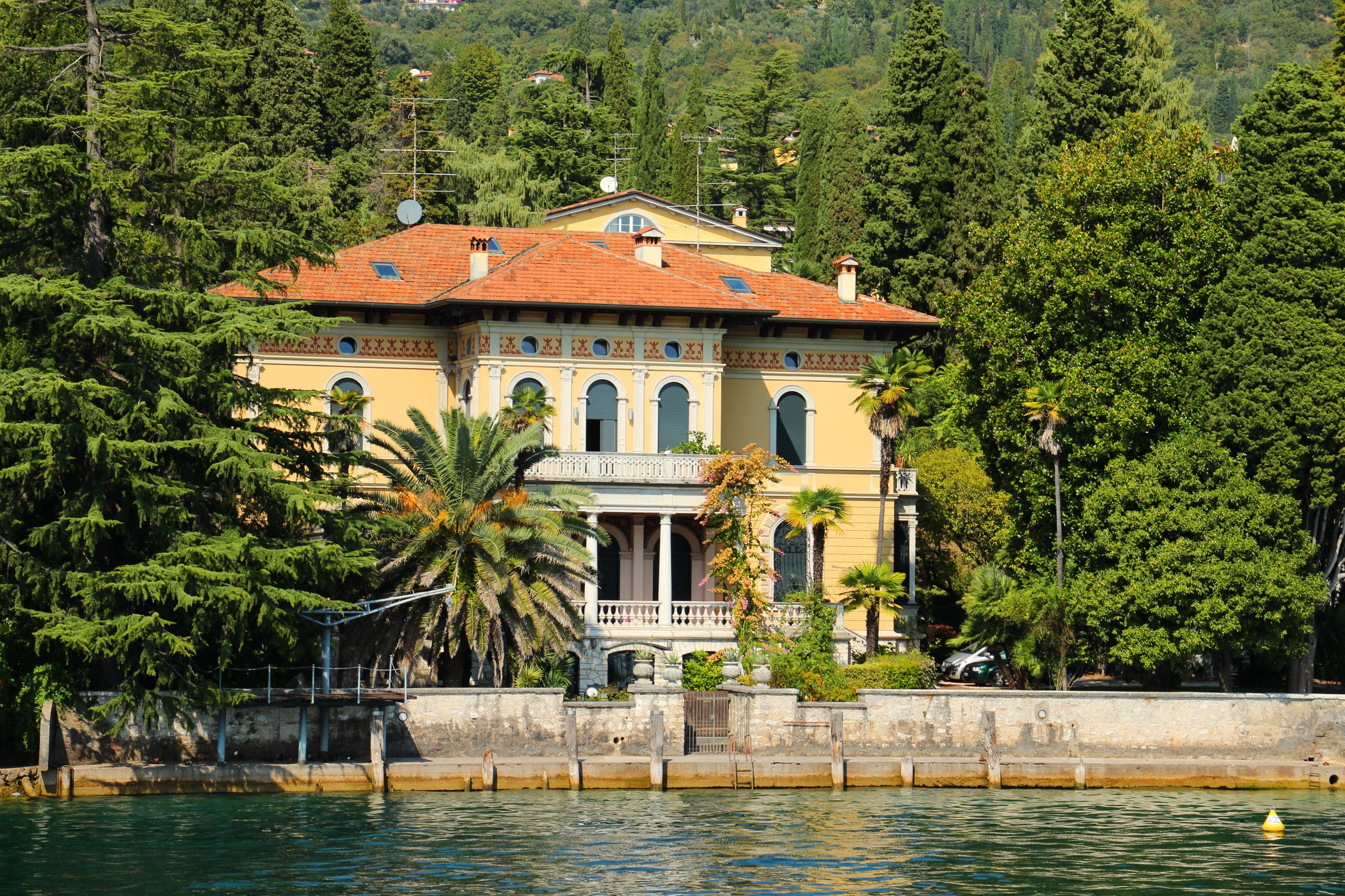Yellow mansion on a lake with palm trees and cypress trees HD Wallpaper
