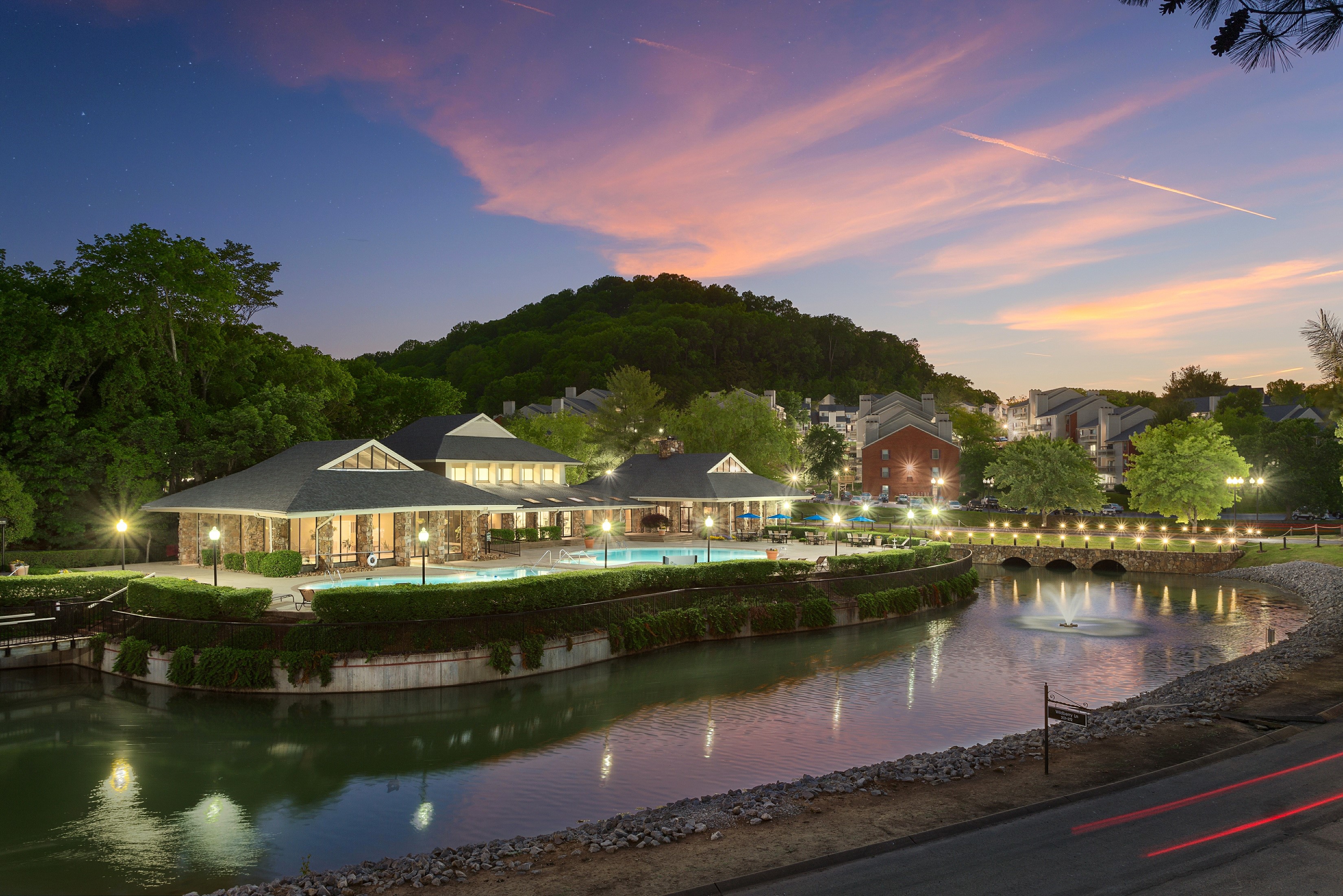 Apartment complex with pool and lake at dusk HD Wallpaper