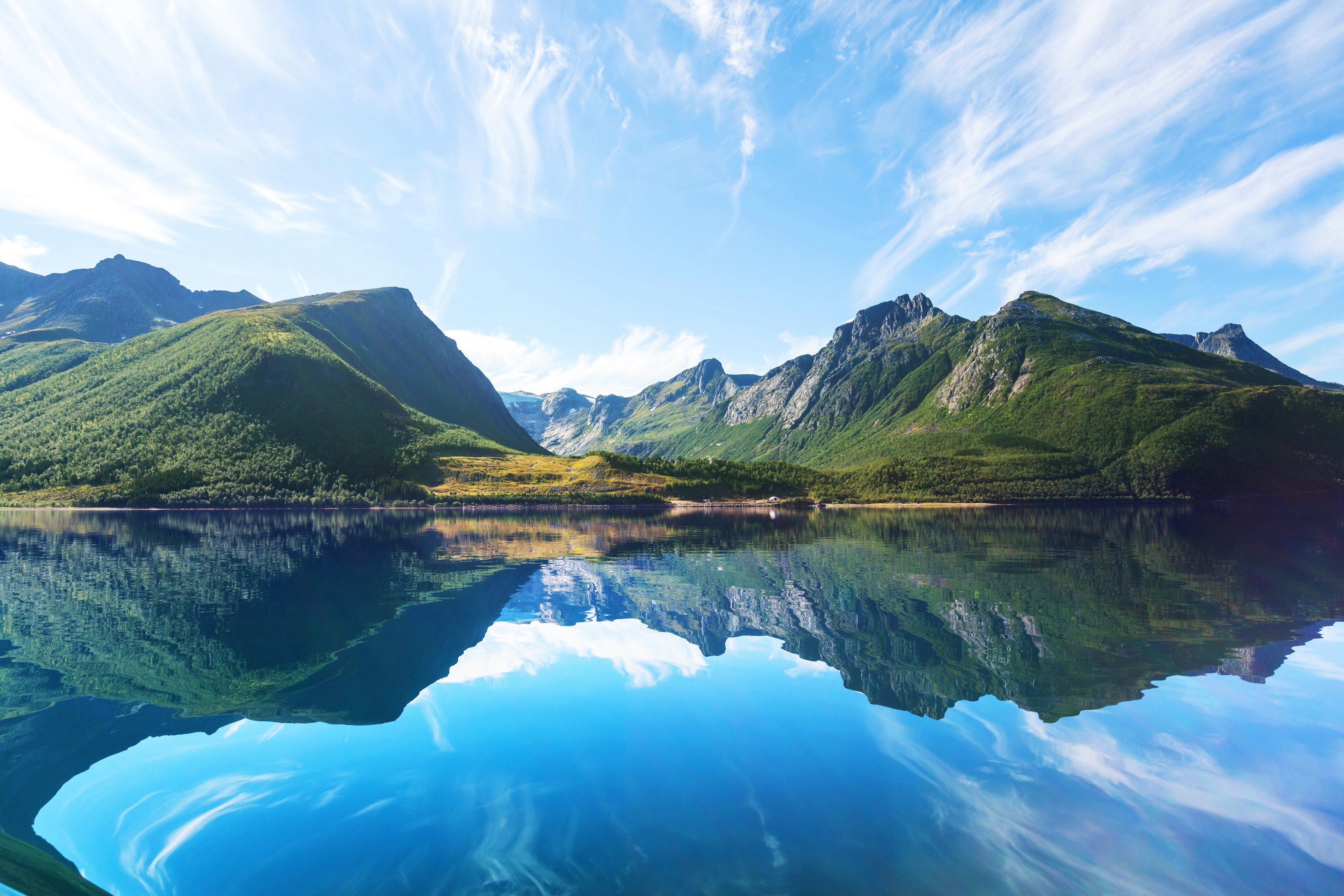 Mountains reflected in a calm lake under a blue sky with wispy clouds HD Wallpaper